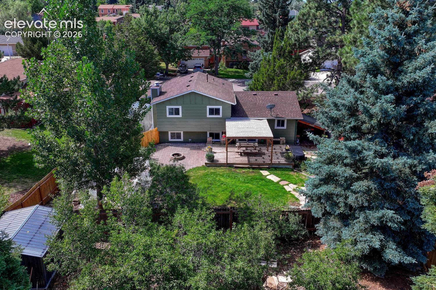 Aerial rear view of home, backyard, and covered carport.