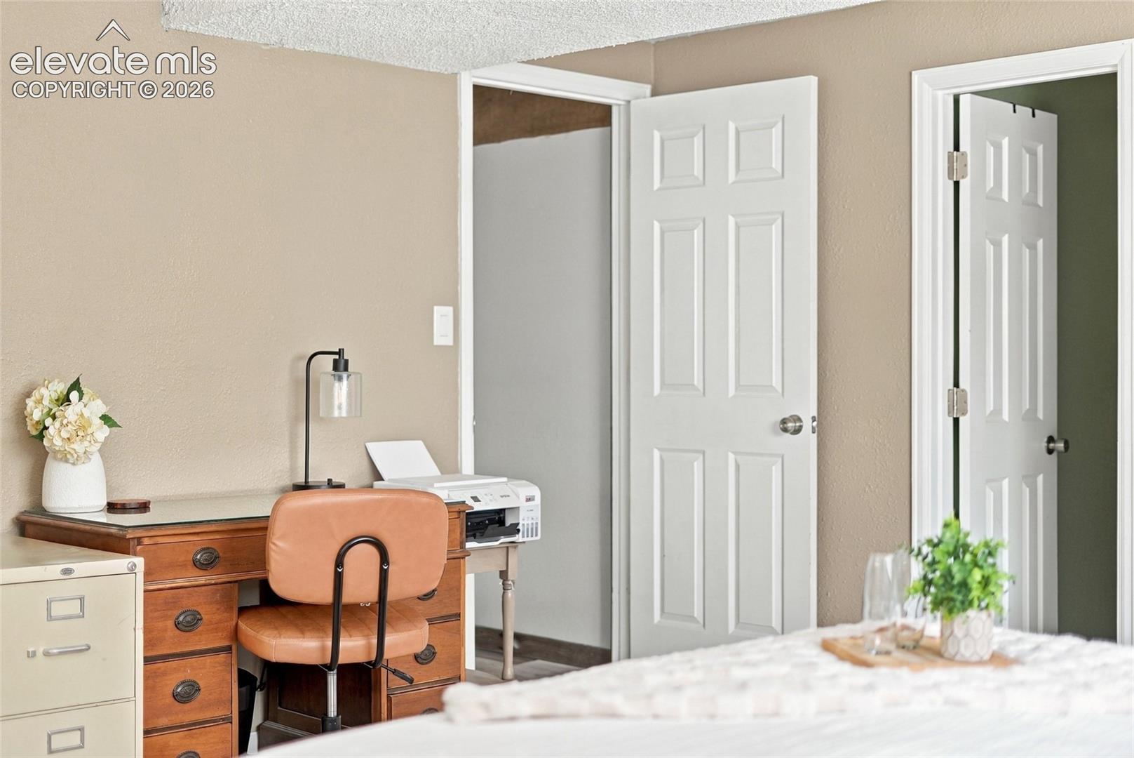 Neutral wall color, white six-panel doors, white trim, and textured ceiling