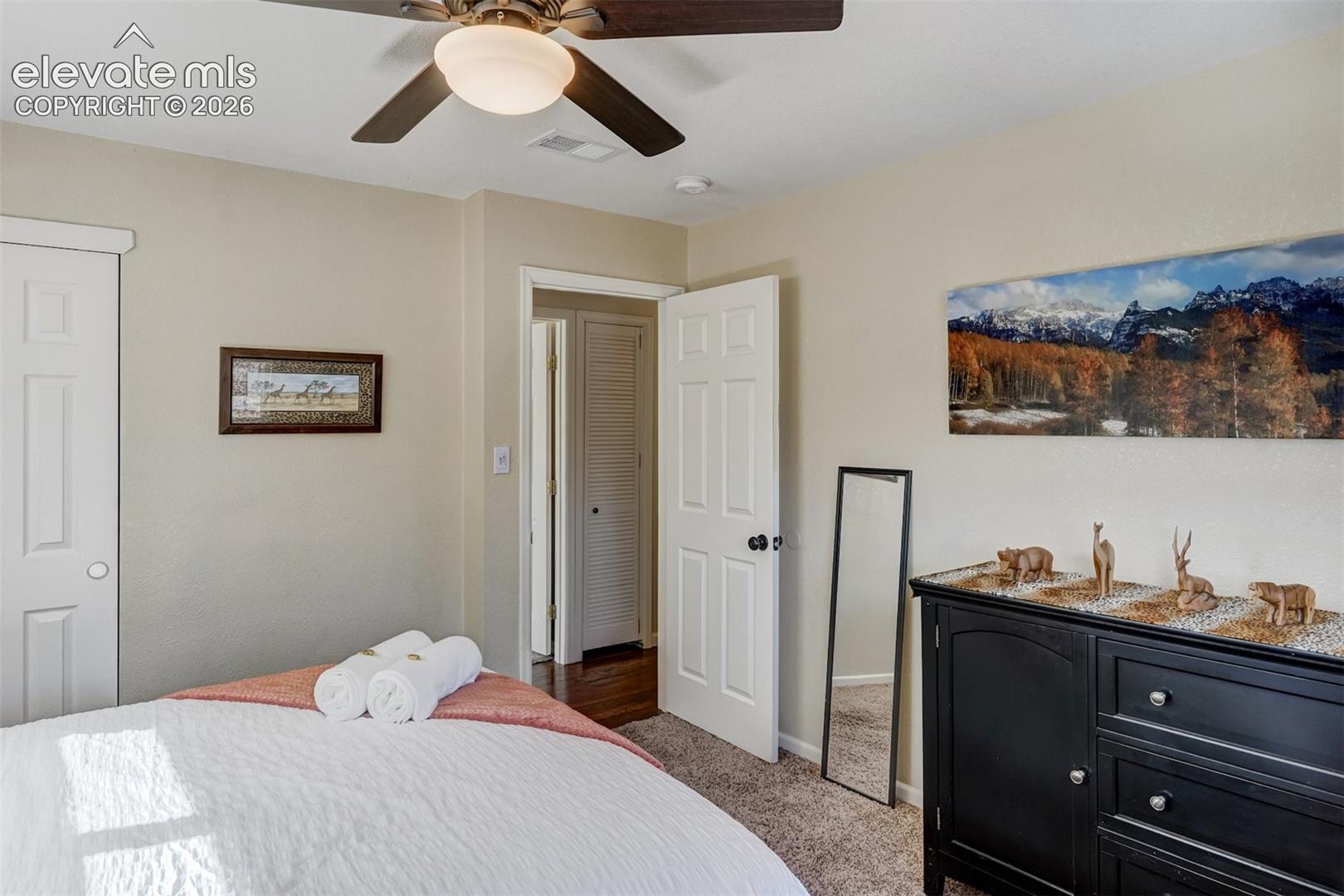 Ceiling fan with integrated lighting, textured carpeting, and white interior doors