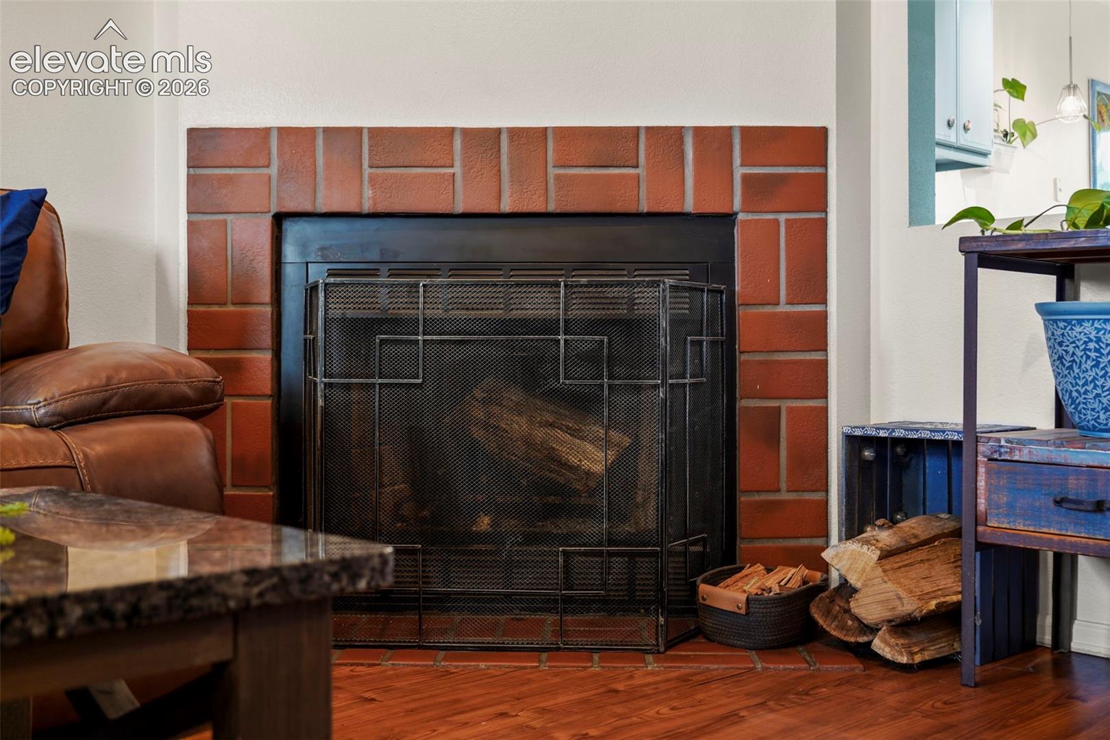 Fireplace featuring a red brick surround, dark metal insert, and matching brick hearth