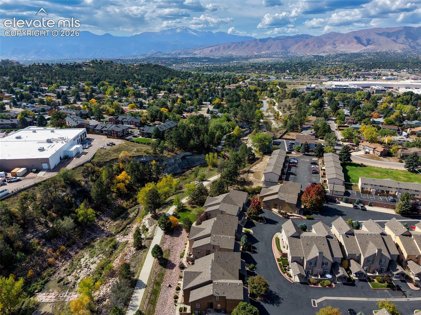Mountain backdrop, treed landscape, residential area, paved roadways, townhome community