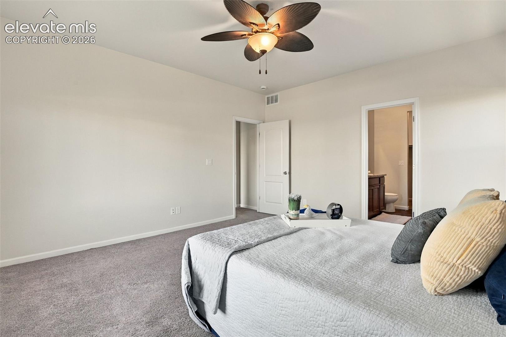 Neutral-toned interior featuring wall-to-wall carpeting, a multi-blade ceiling fan with integrated lighting, and white interior doors