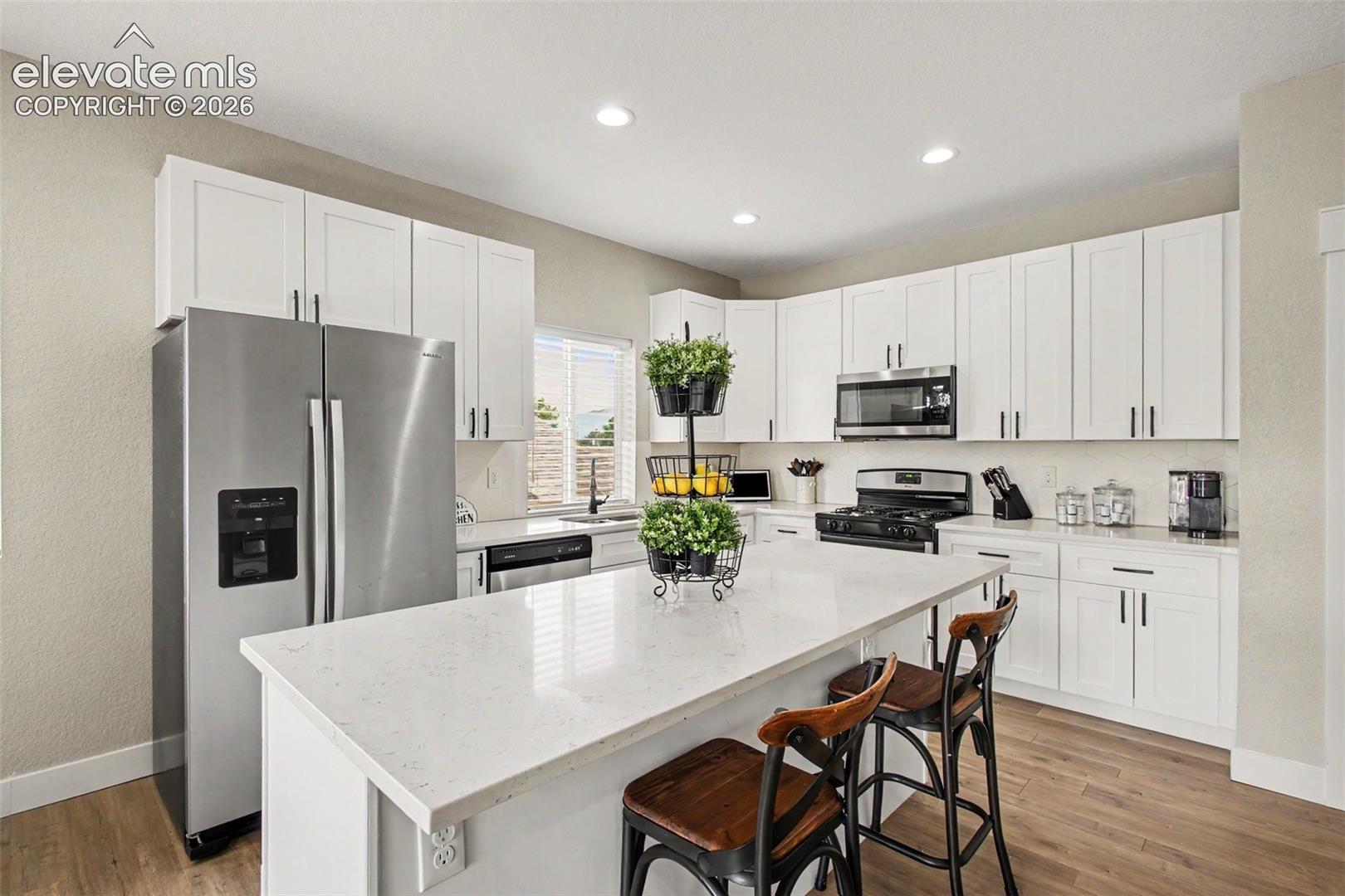 Quartz countertops, shaker-style cabinetry, stainless steel appliances, and an oversized island provide both beauty and functionality!
