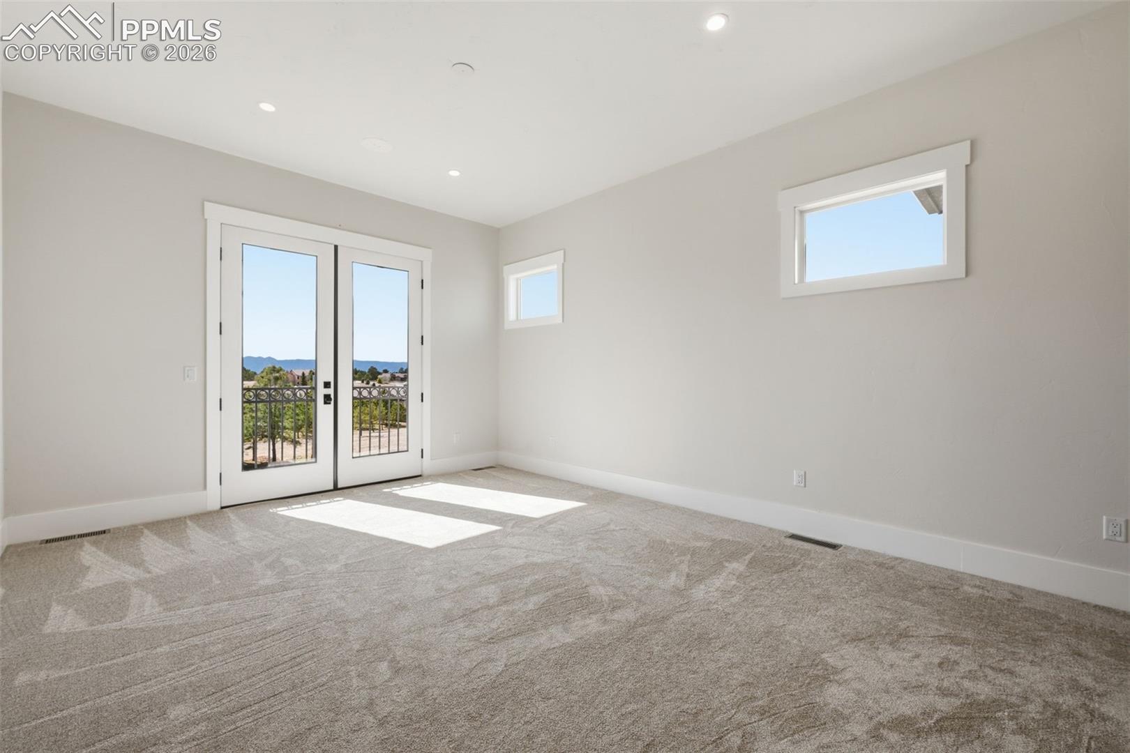 Master Bedroom Suite with French doors, light carpet, natural light, and recessed lighting.