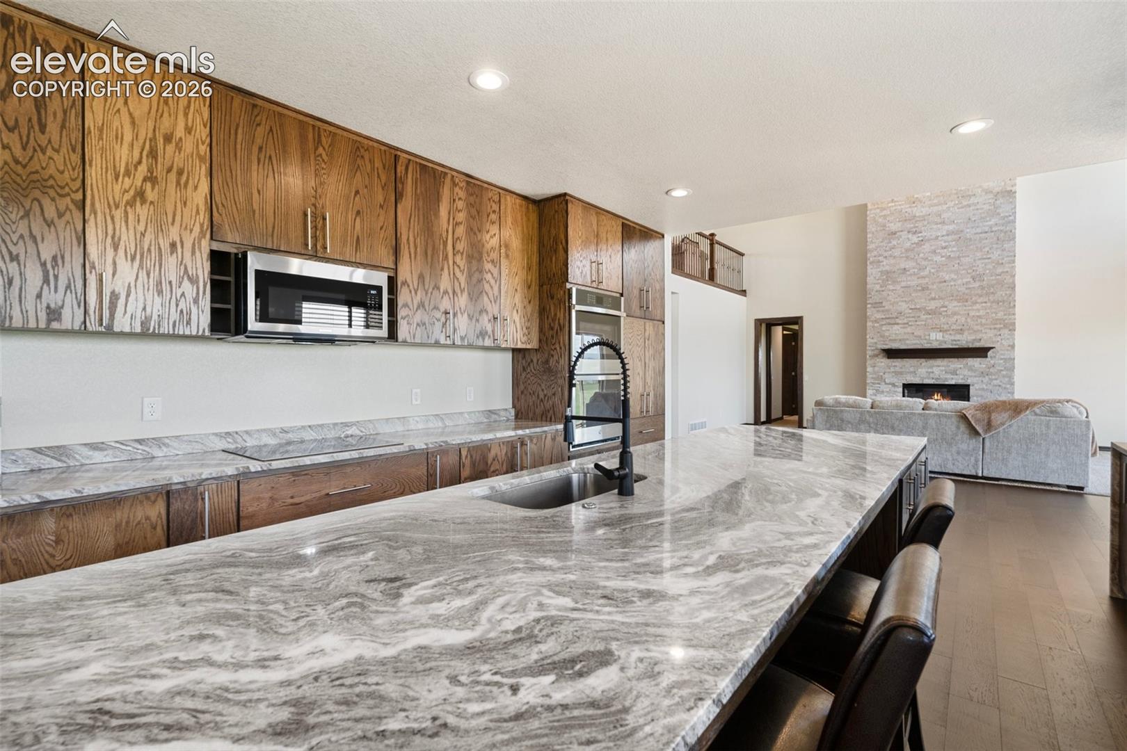Spacious kitchen island with a dark basin sink and a contemporary gooseneck faucet