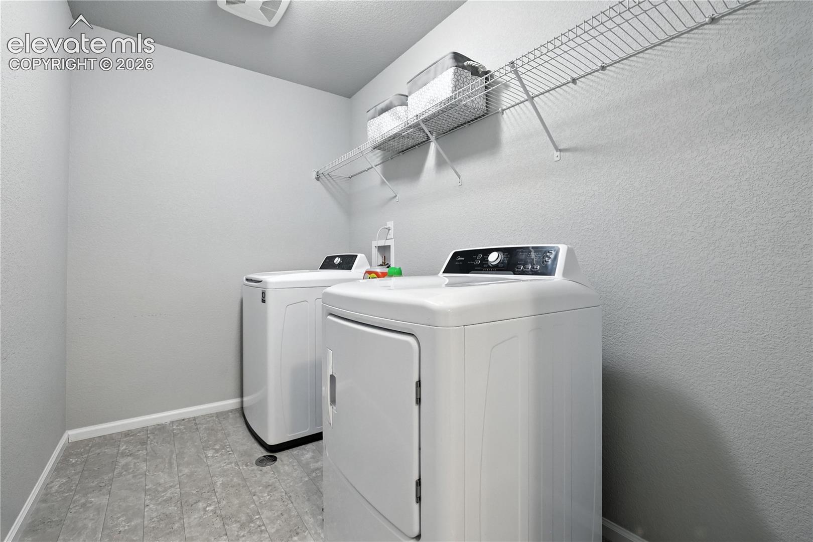 Utility room featuring a wire shelving unit and textured walls