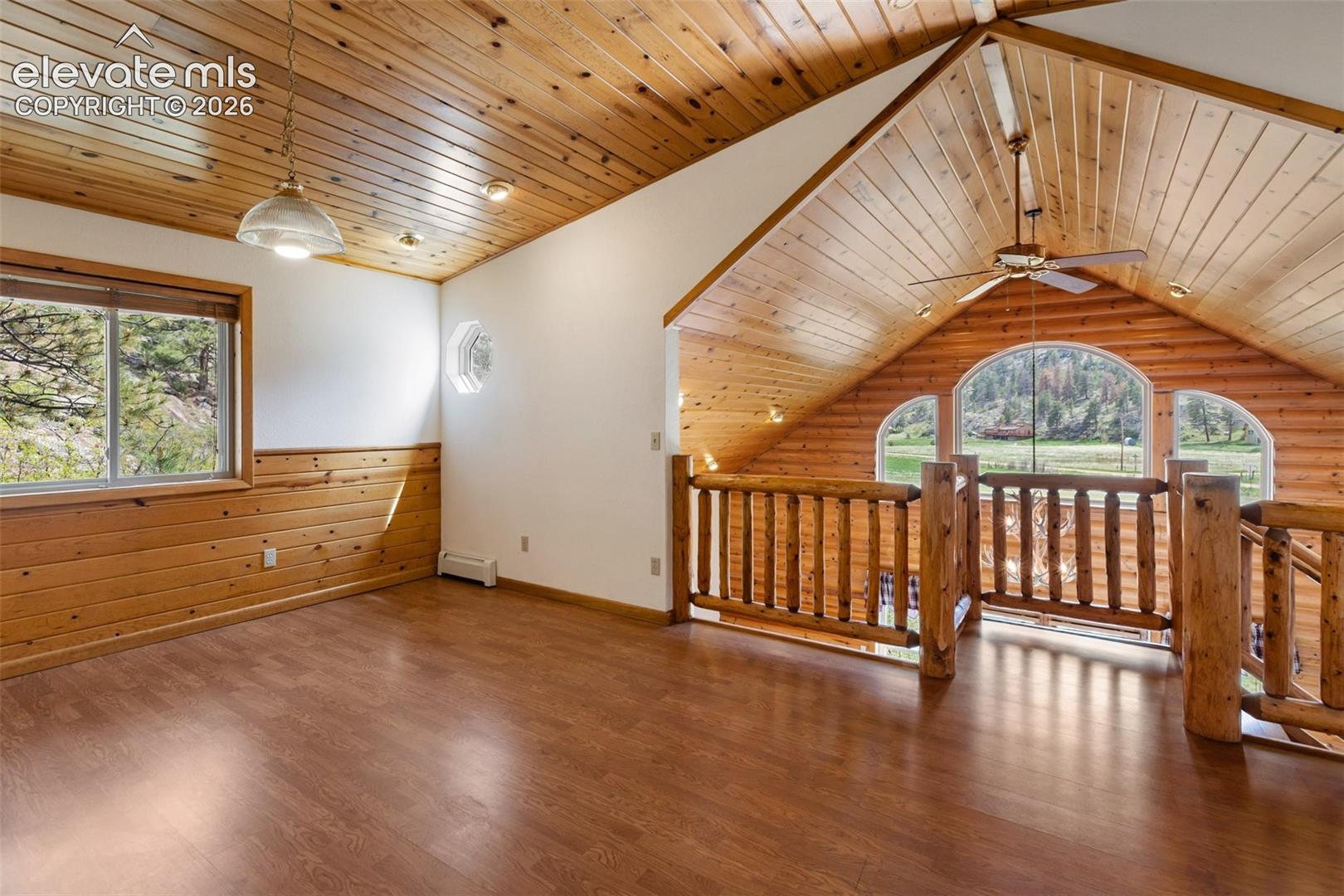 Upper level living area,Pine tongue-and-groove ceilings, a stunning antler chandelier, expansive windows, and beautiful views create a warm and inviting mountain retreat.