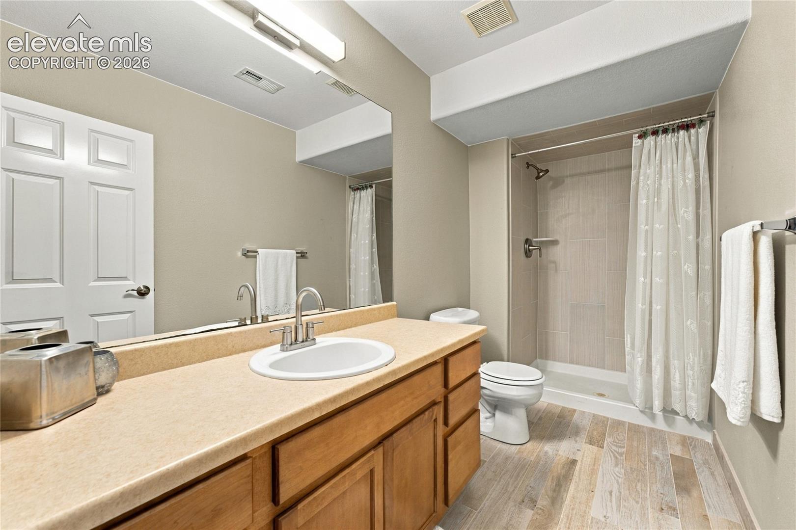 basement bath with new light fixture, hardware and floor to ceiling shower tile