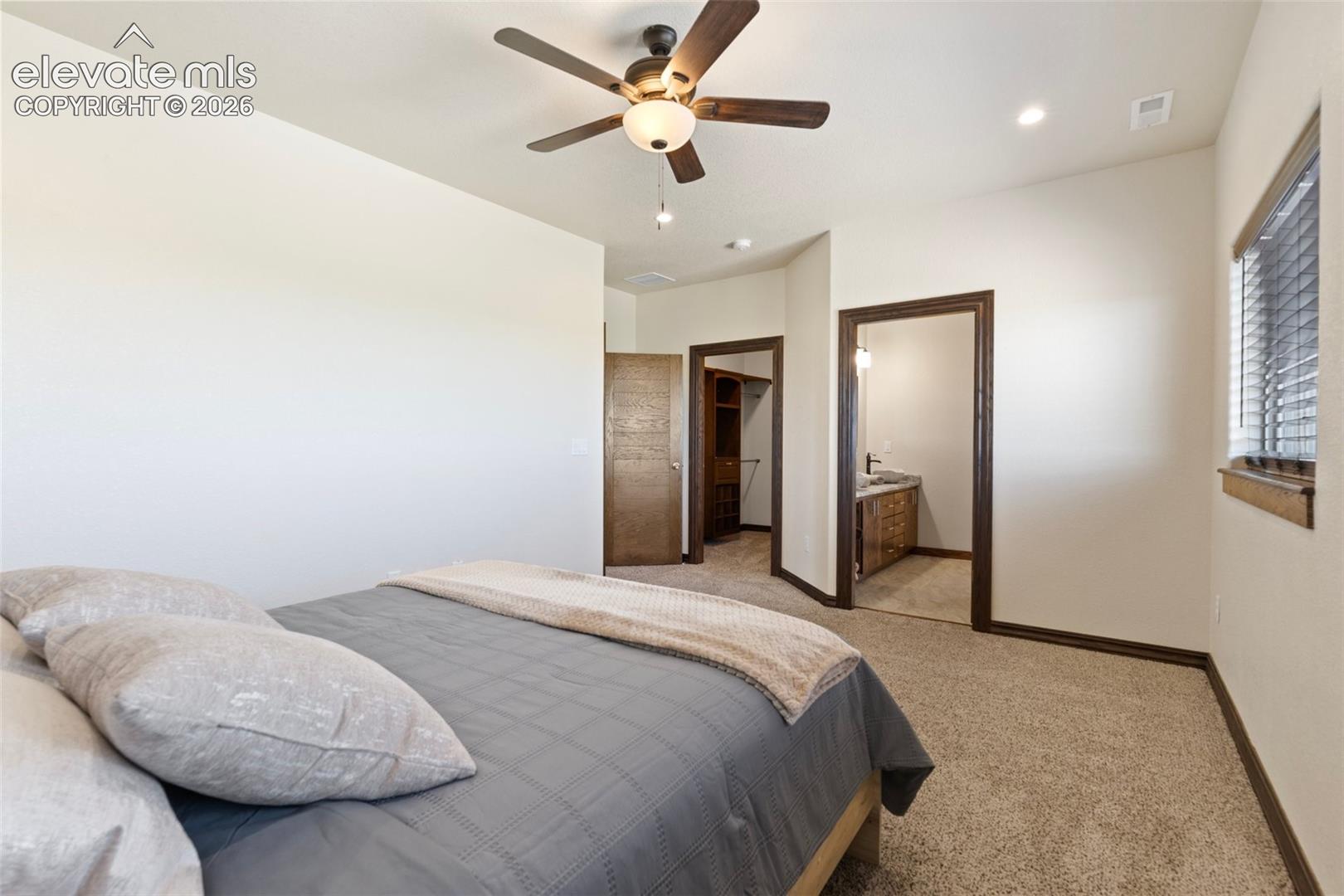Carpeted room featuring a ceiling fan with integrated lighting, recessed lighting, and a window with blinds
