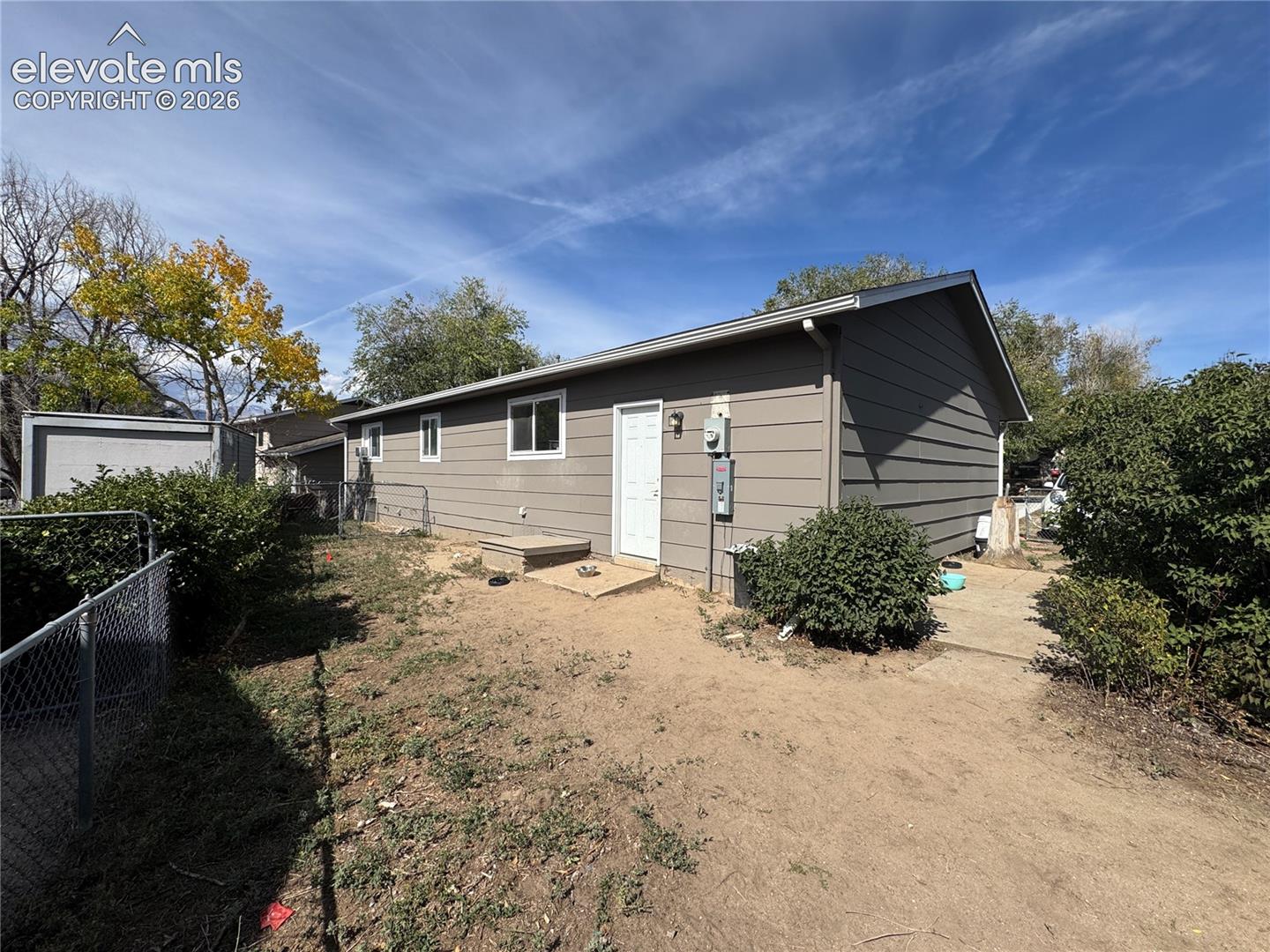 Siding exterior with multiple windows, concrete walkway, and established landscaping