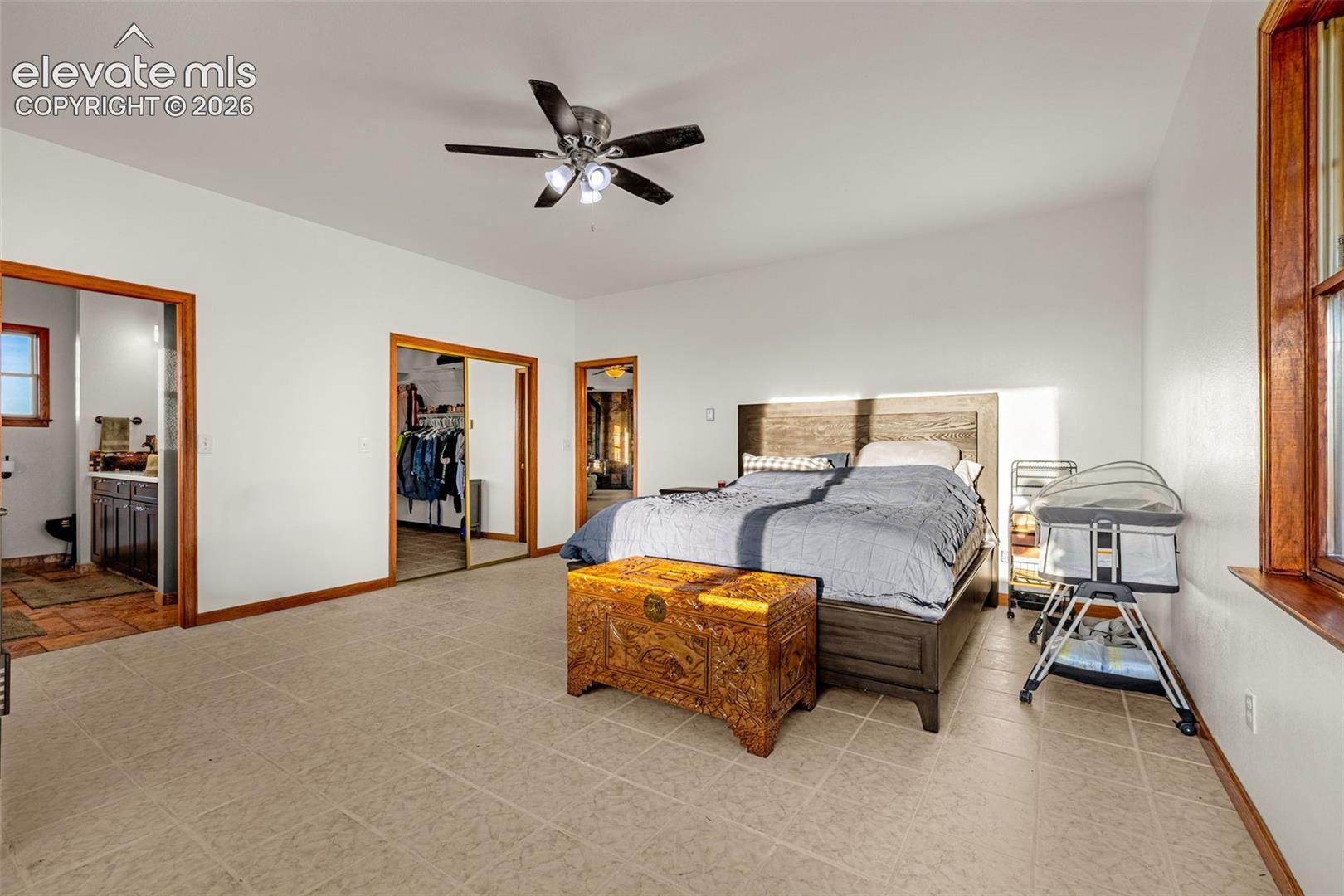 Expansive room with tiled flooring and a ceiling fan