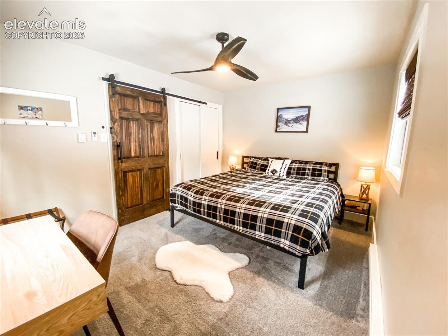 Bedroom featuring a rustic wood barn door, gray wall paint, and recessed lighting