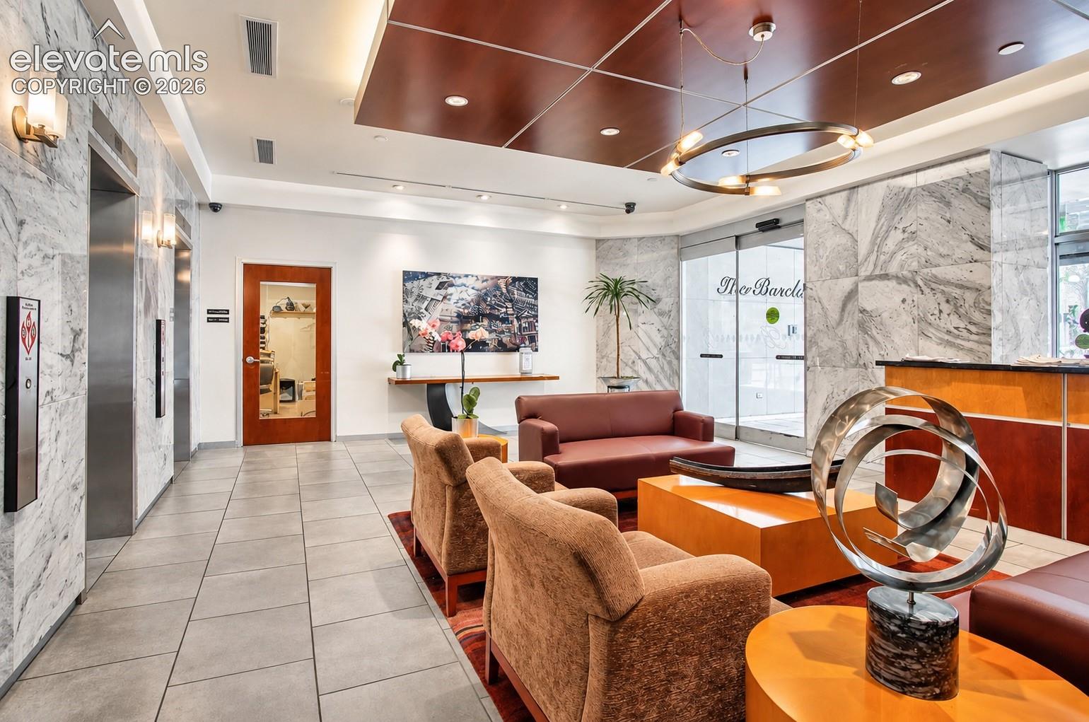 Lobby featuring marble-clad walls, recessed lighting, and a wood-paneled ceiling