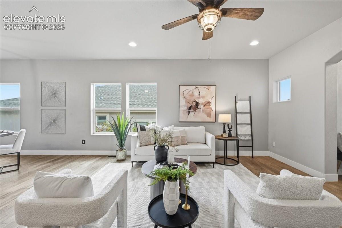 Spacious living area featuring wood-finish flooring, recessed lighting, and a ceiling fan
