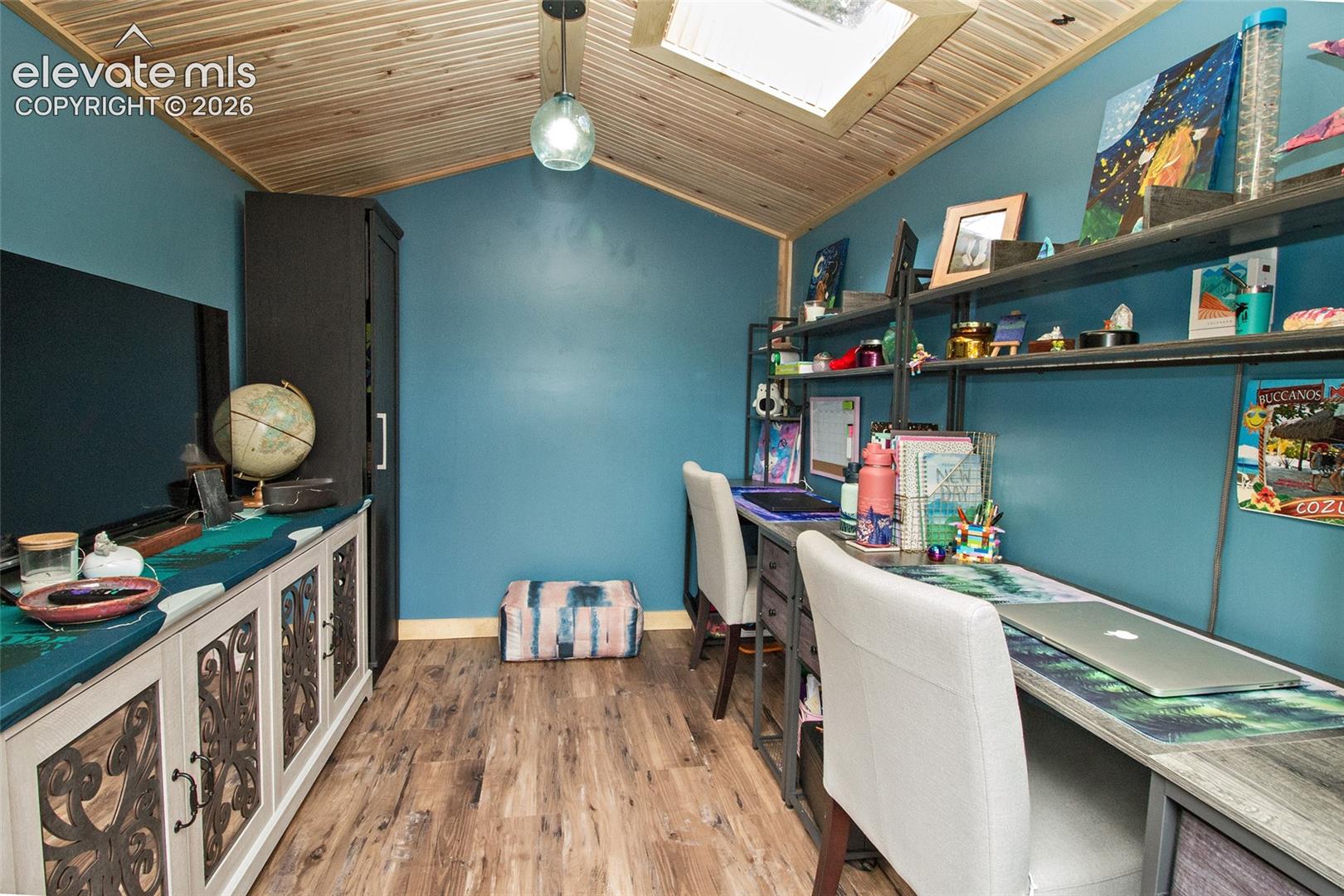 Flex space with vaulted wood-plank ceiling featuring a built-in skylight, wood-finish flooring, and recessed pendant lighting