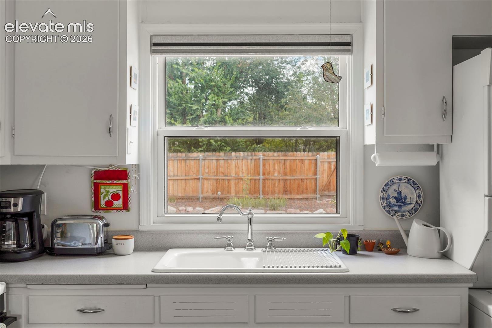 Porcelain sink overlooking yard and patio