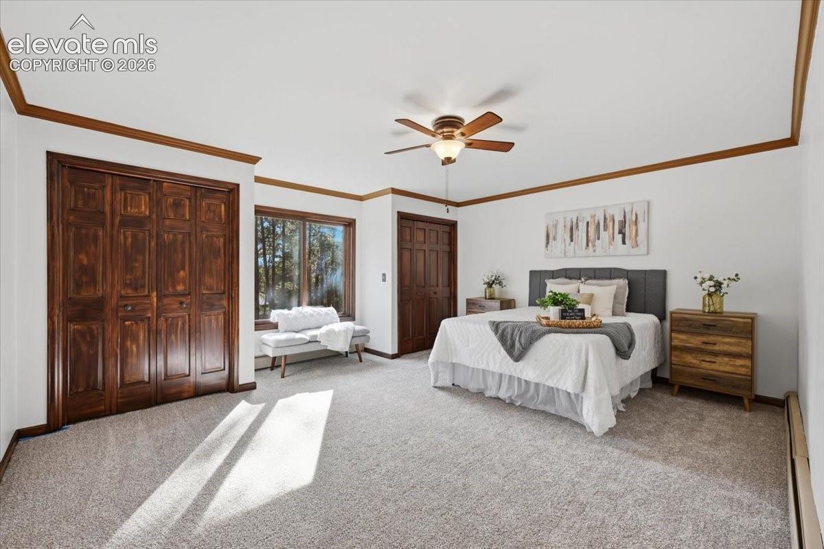 Spacious room featuring wood-finish trim, multiple windows, a ceiling fan, and bi-fold closet doors
