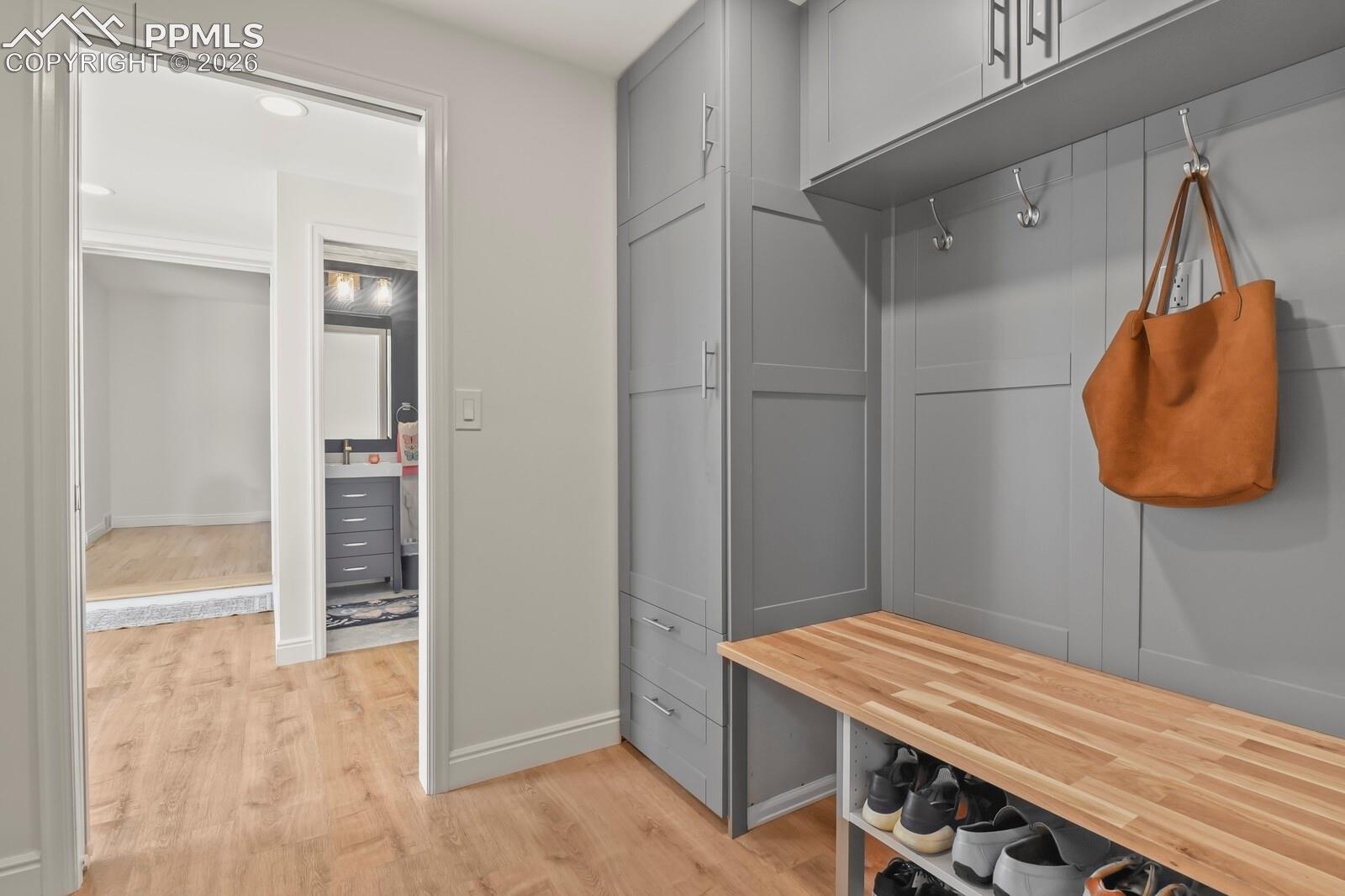 Built-in gray cabinetry with a bench and shoe storage