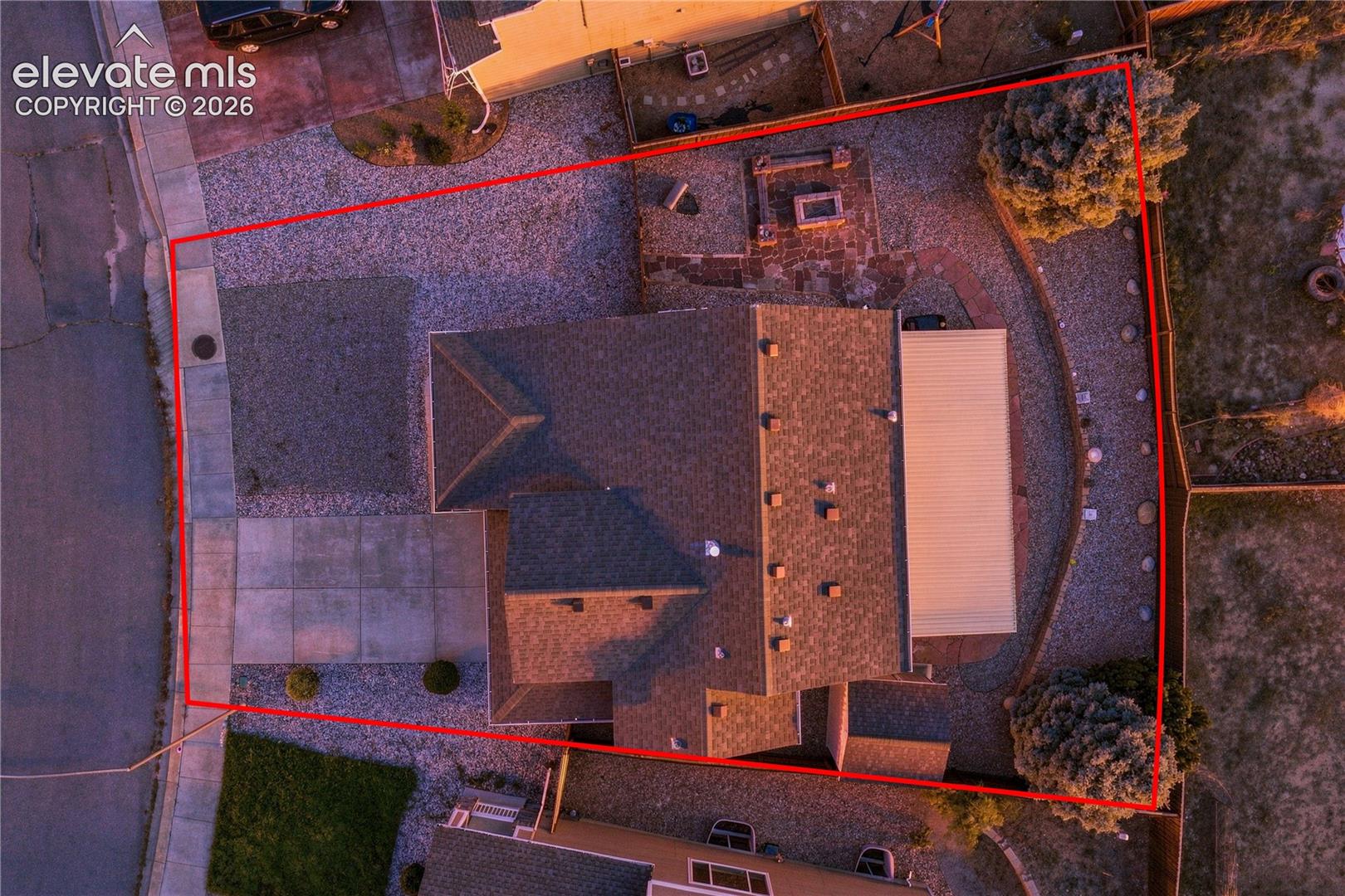 *Property Lines are approximate and not a survey.* Asphalt shingle roof, gravel landscaping, concrete driveway, concrete patio, and a covered outdoor structure. Lot lines approximate