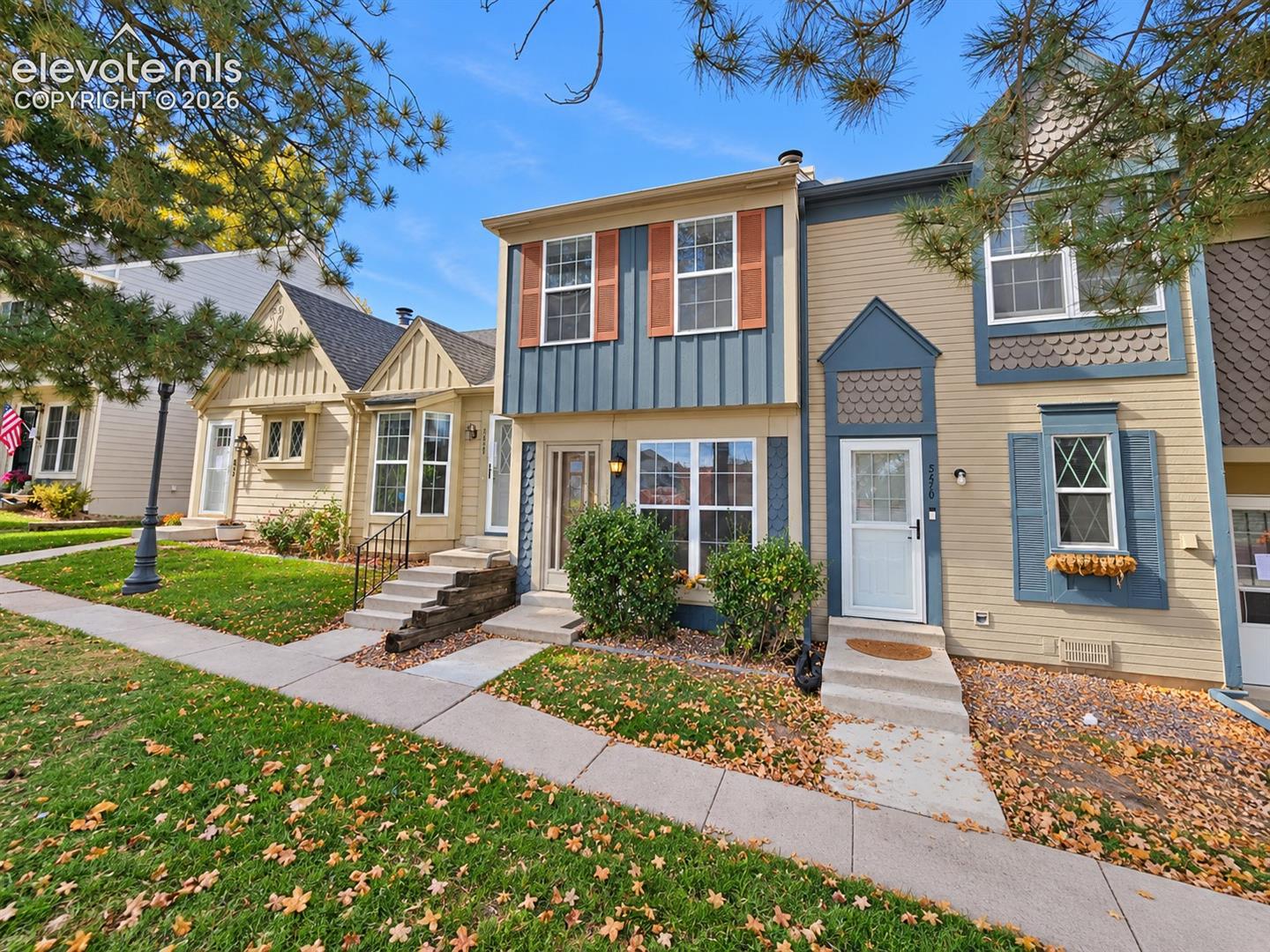 Multi-level exterior featuring vertical board-and-batten and horizontal siding, decorative shingle accents, multi-pane windows, and concrete walkways