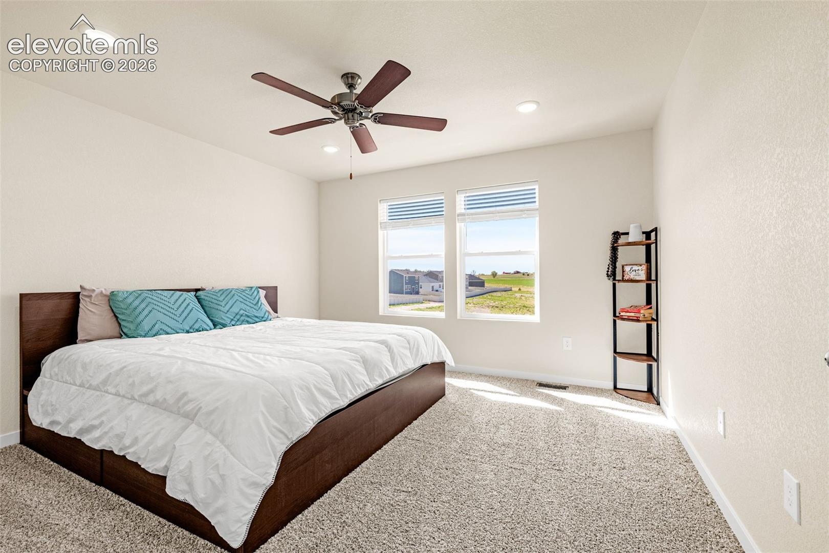 Recessed lighting, ceiling fan, carpeting, two large windows, and neutral wall tones