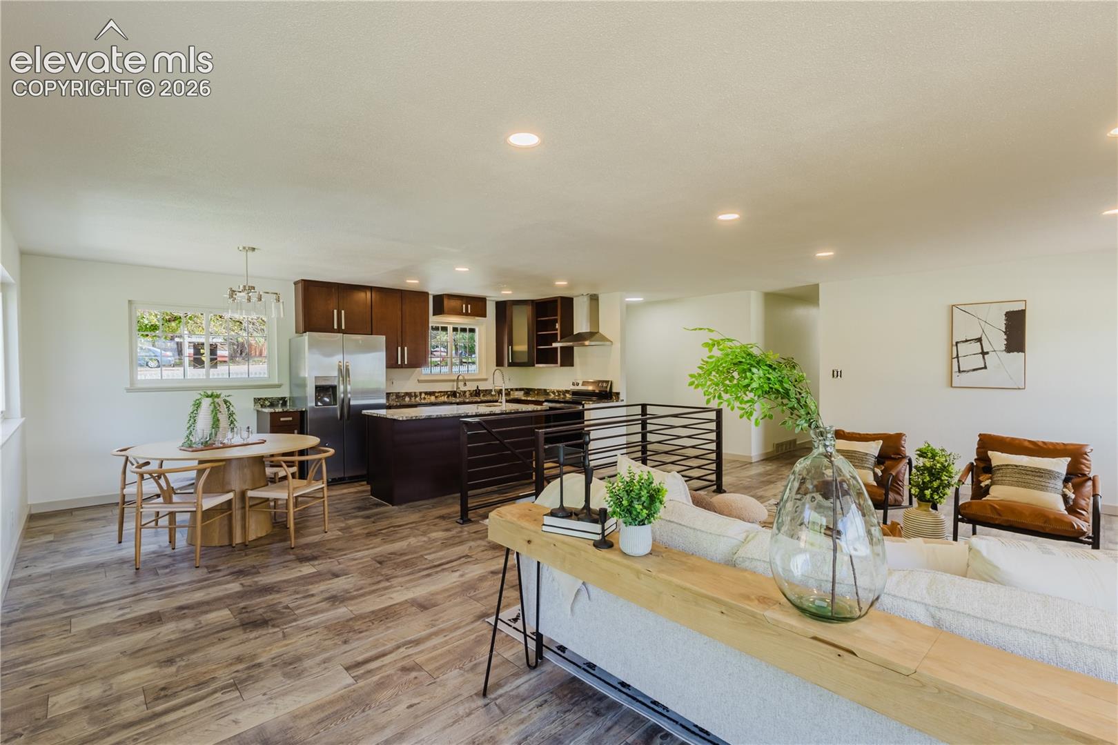 Open-concept living space featuring wood-finish flooring, recessed lighting, and a contemporary kitchen