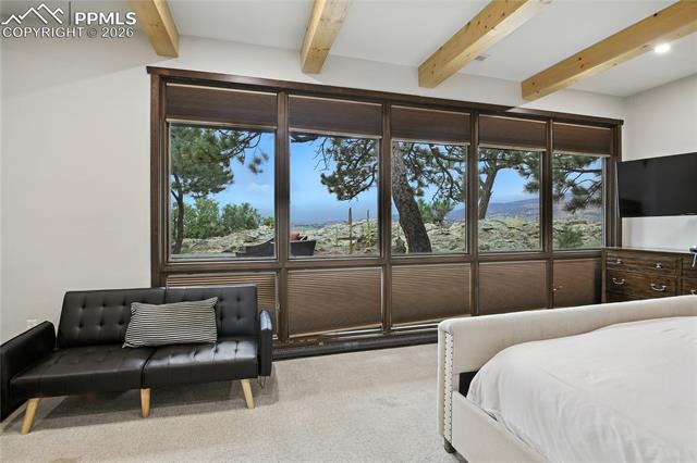 Bedroom with beamed ceiling and carpet floors