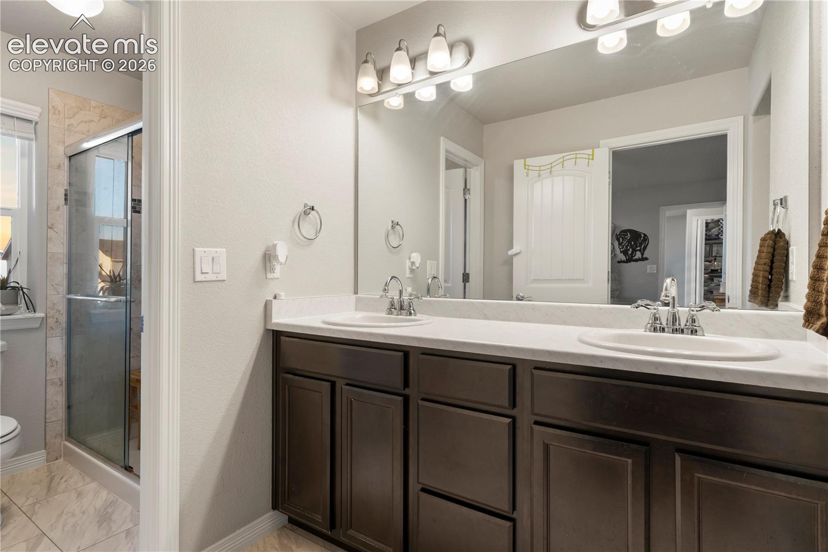 Double vanity, walk in shower, and spacious walk in closet