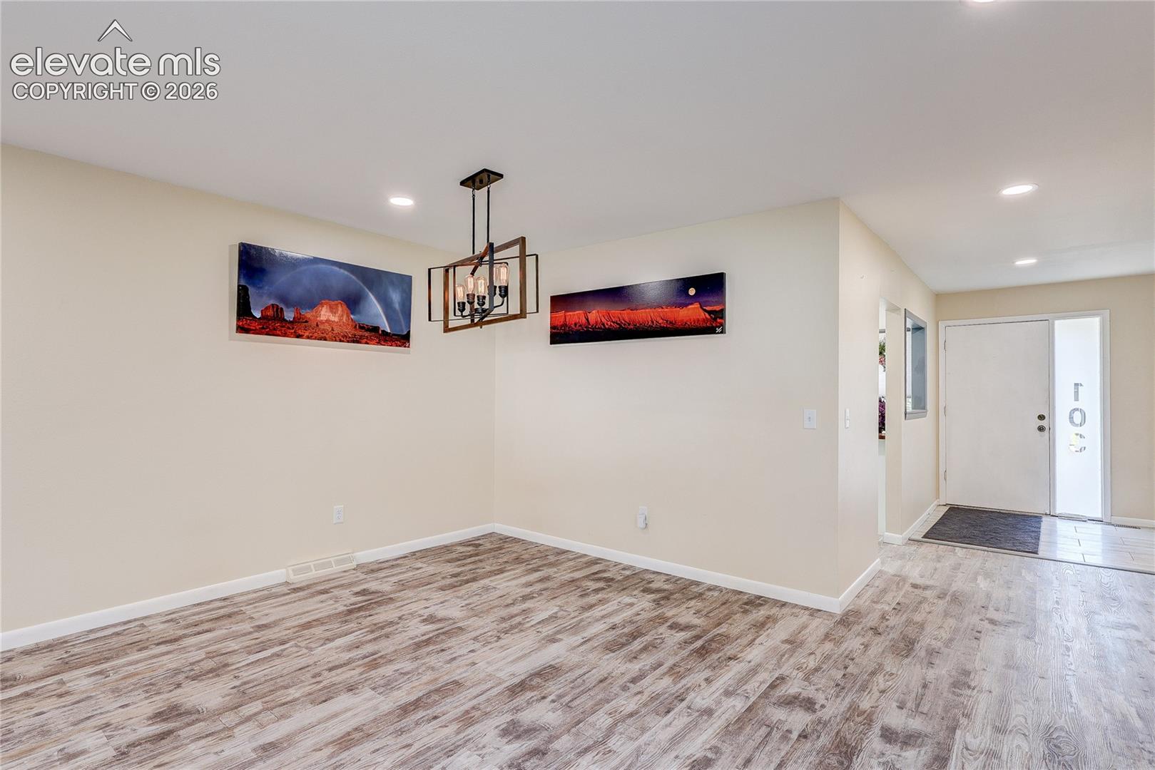 Wood-finish flooring, recessed lighting, and a geometric-frame pendant light fixture