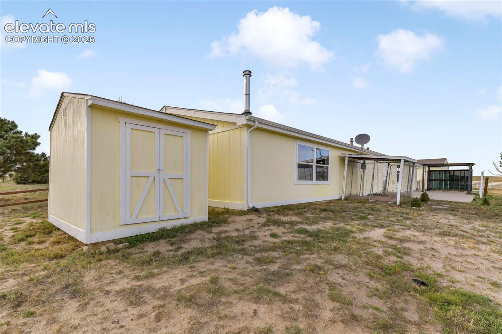 Exterior featuring a detached storage shed, covered patio, and a secondary covered outdoor structure