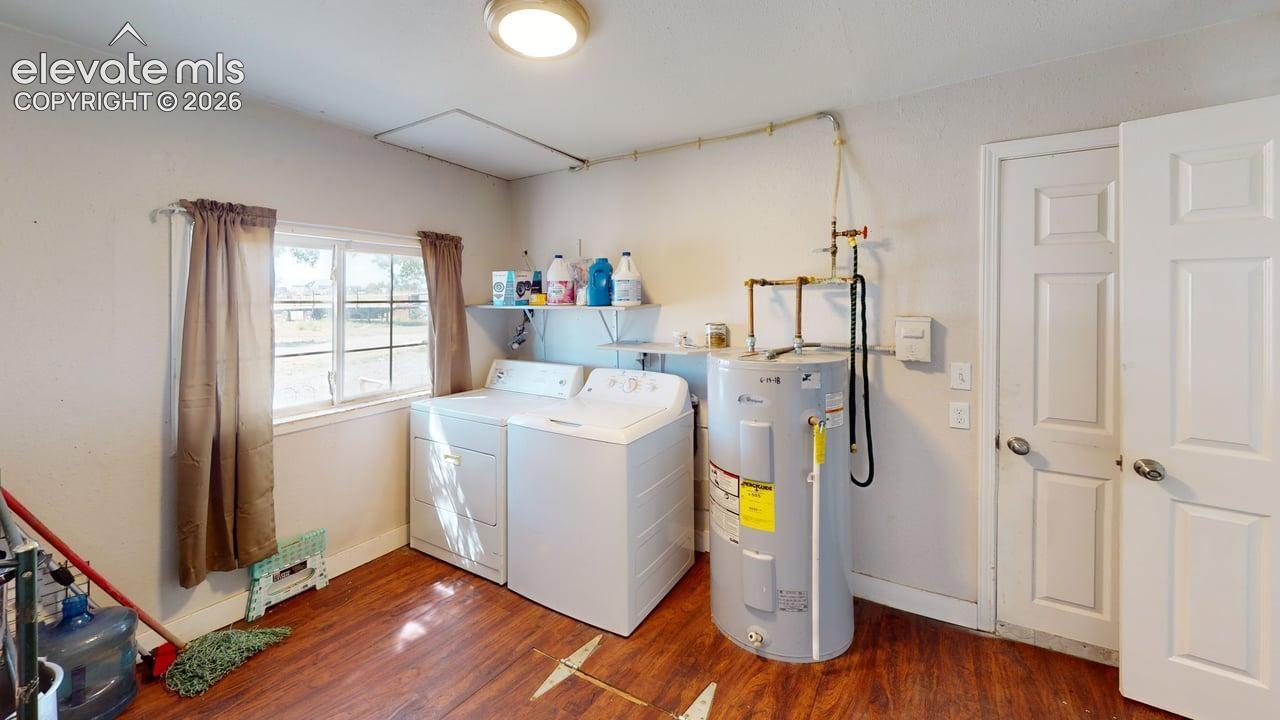 Laundry area featuring wood-finish flooring, a window, and overhead lighting