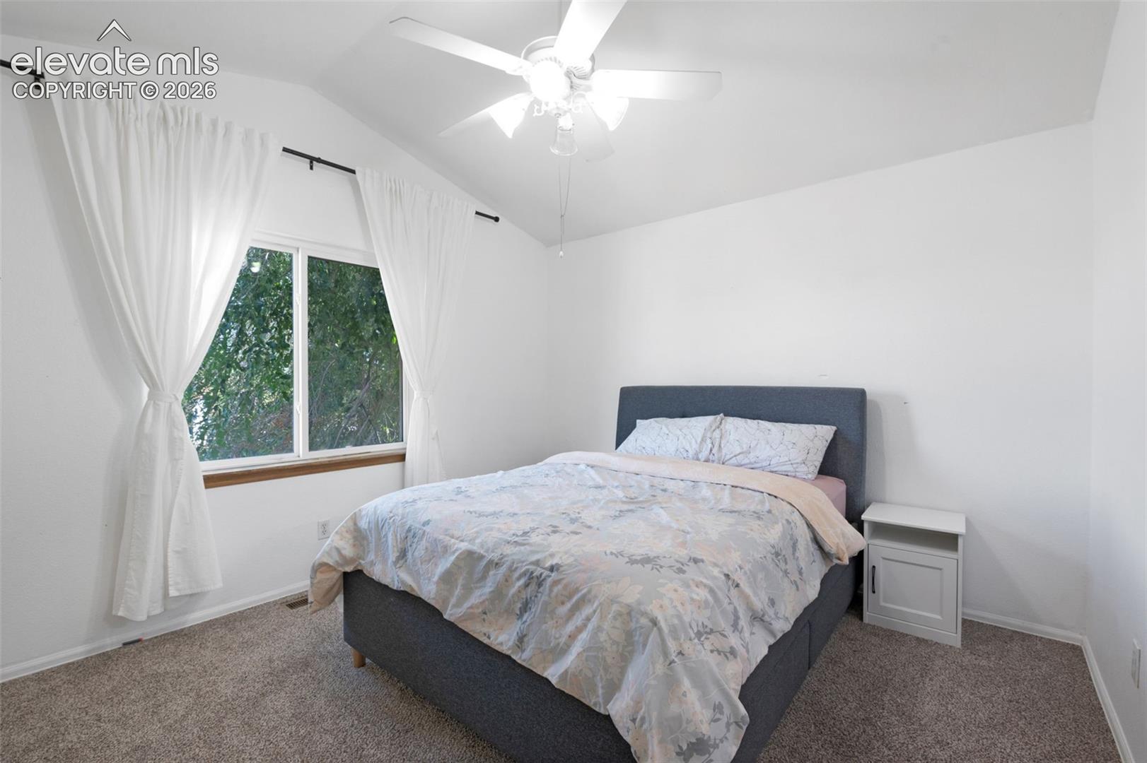 Interior room with vaulted ceiling and a ceiling fan light fixture