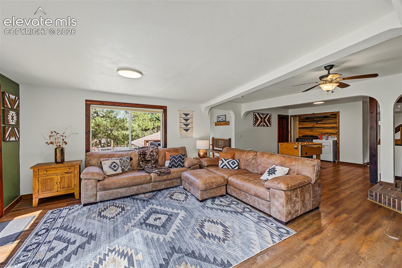 Spacious living area featuring wood-finish flooring, a large window, and recessed lighting