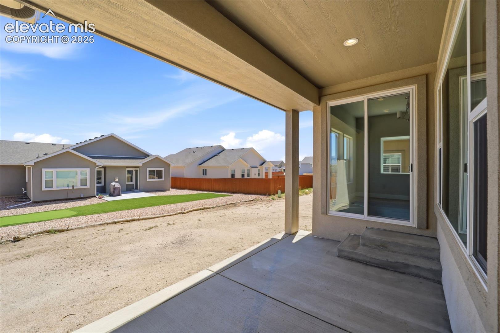 Covered concrete patio with recessed lighting and sliding glass door entry