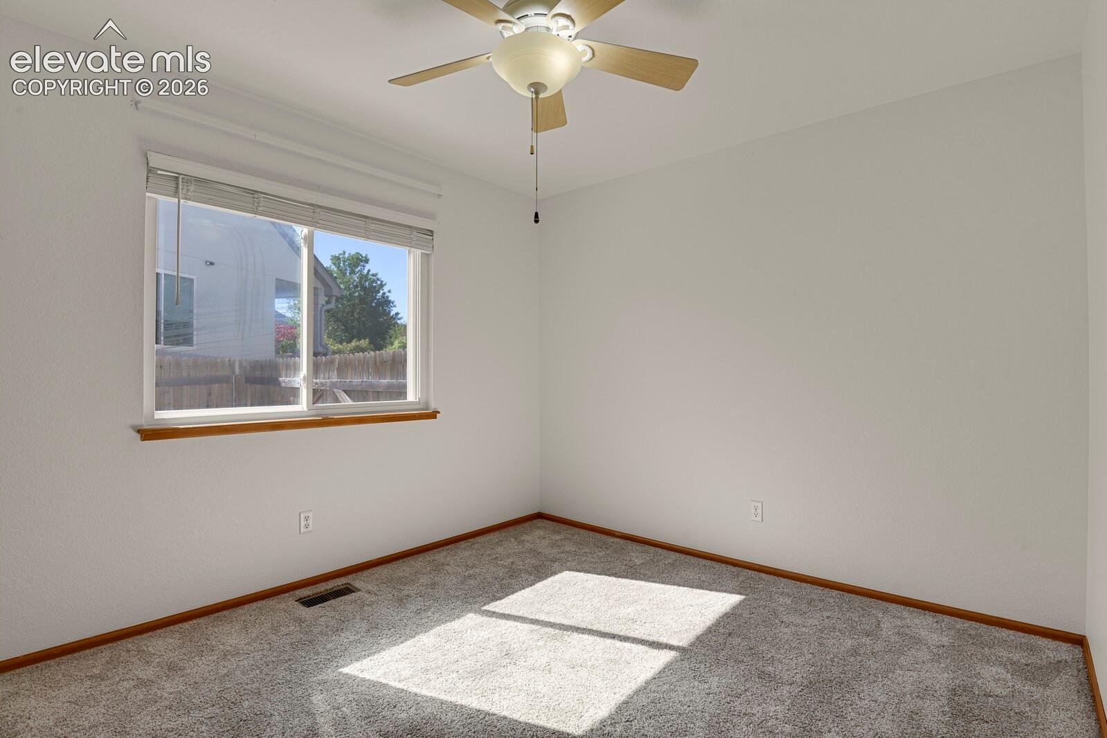 Wall-to-wall carpeting and a ceiling fan with integrated lighting