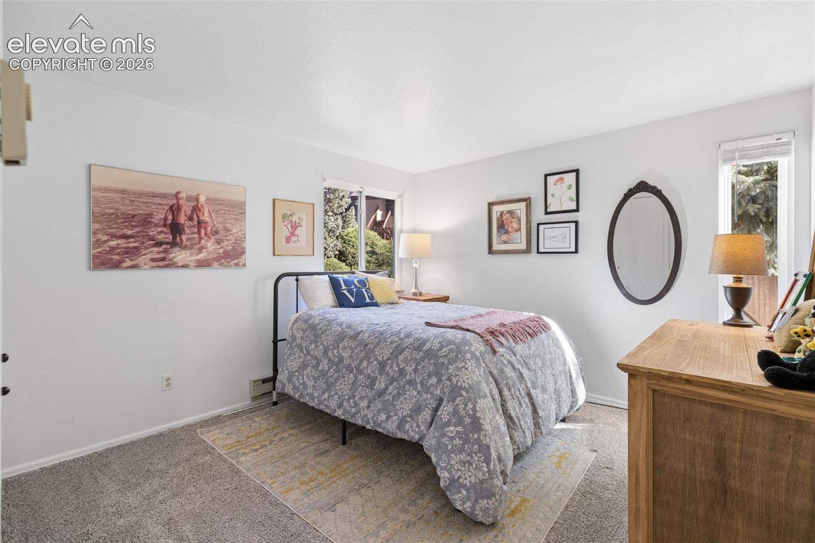 Carpeted flooring, white painted walls, and window with natural light