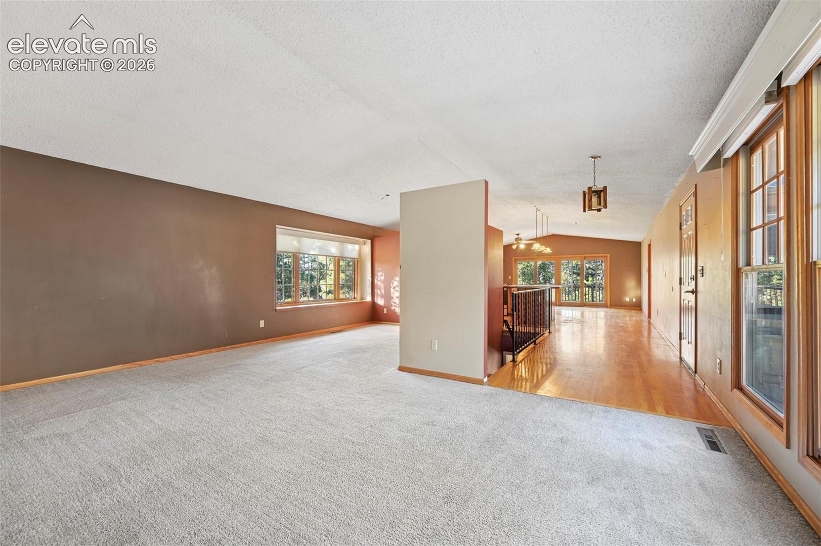 Carpeted living area with a large bay window