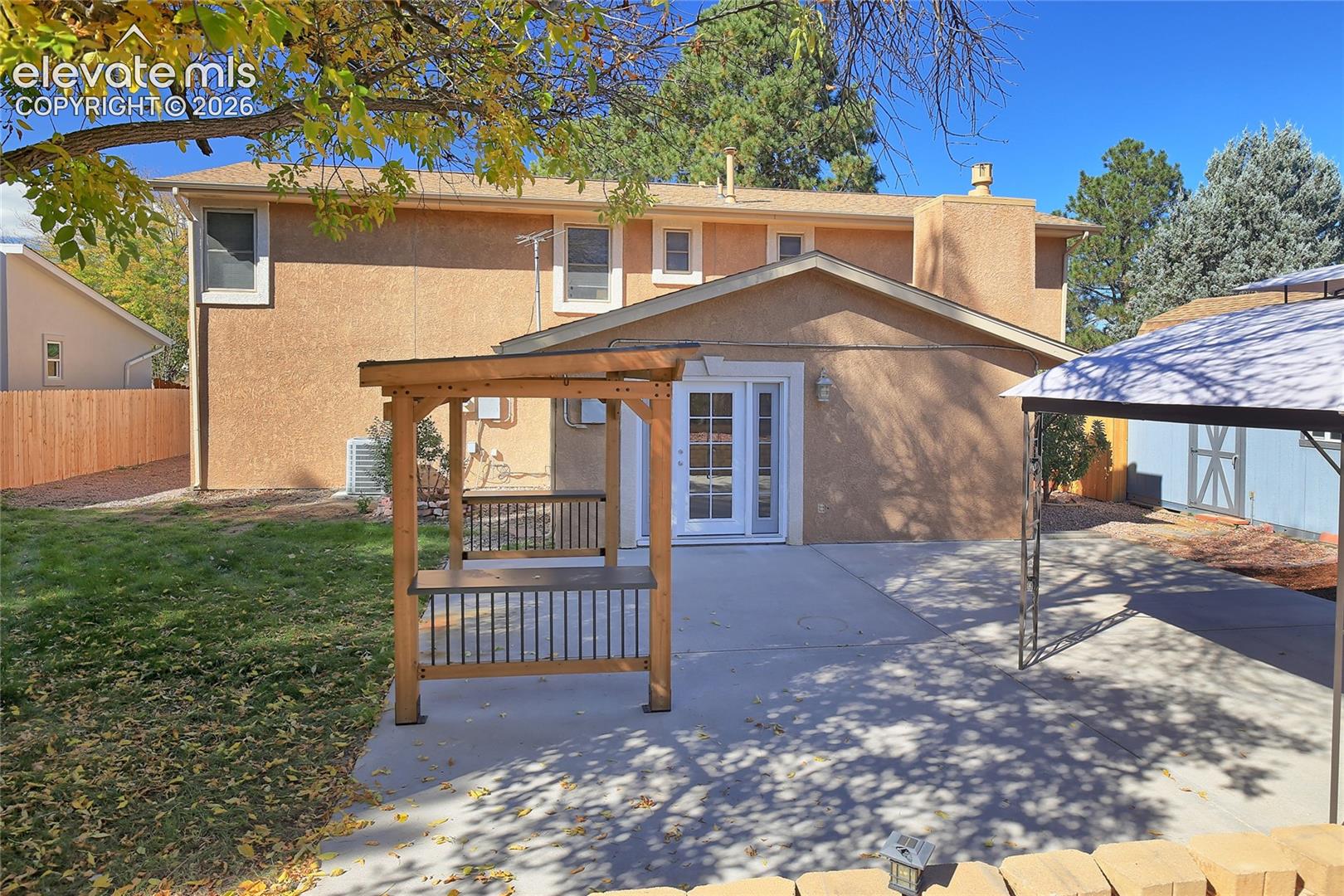 Back yard features a secure pergola, extensive patios and covered area for grilling