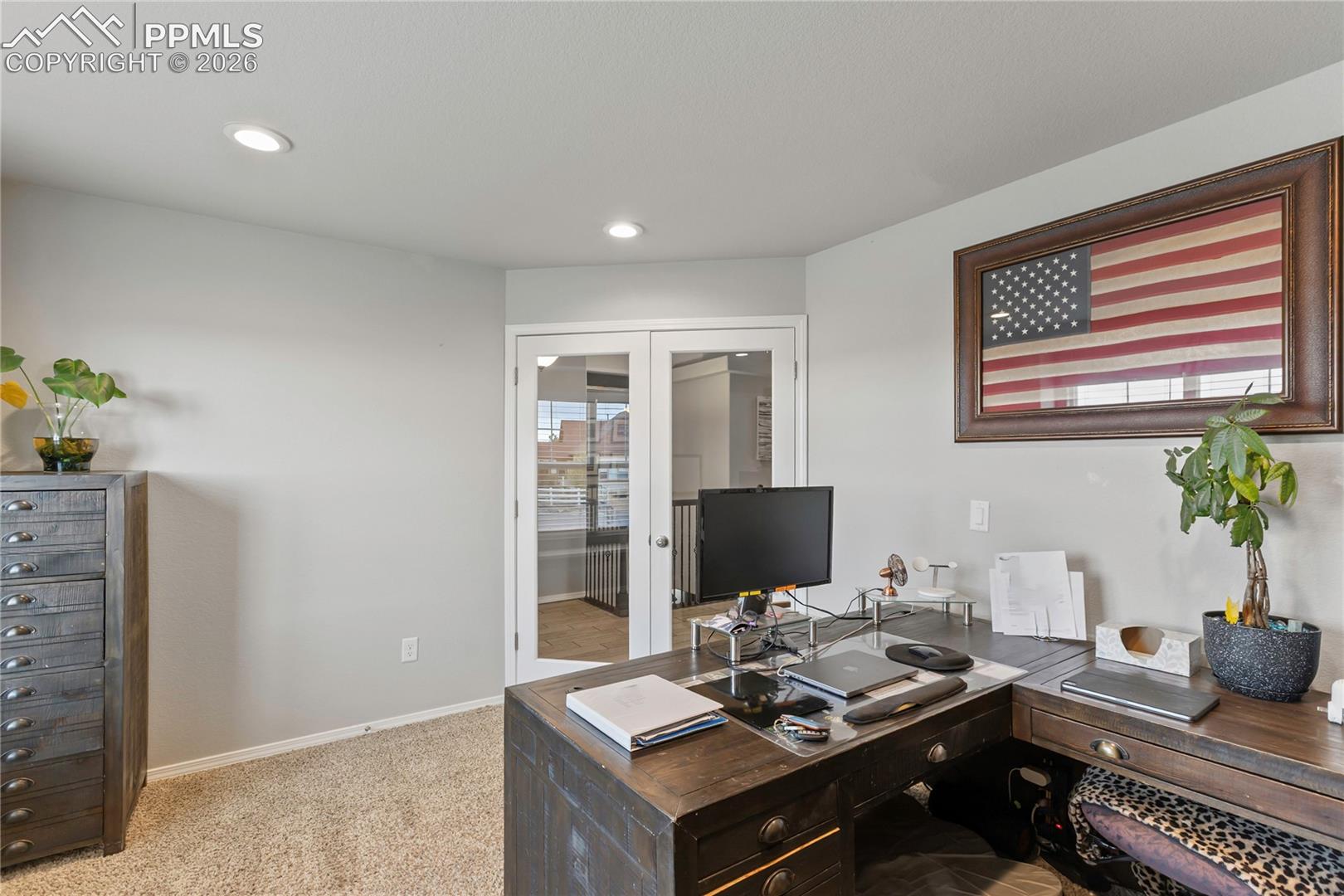 Office with double French doors with glass panels, recessed ceiling lighting, light gray wall paint, and textured carpeting