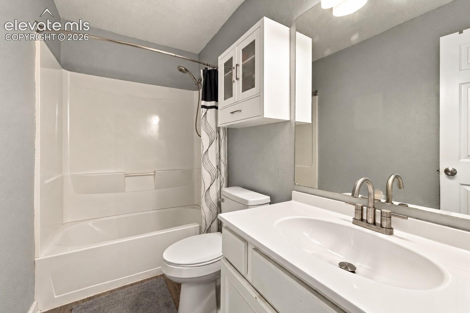 Integrated vanity with an undermount sink, brushed nickel faucet, and a large wall-mounted mirror