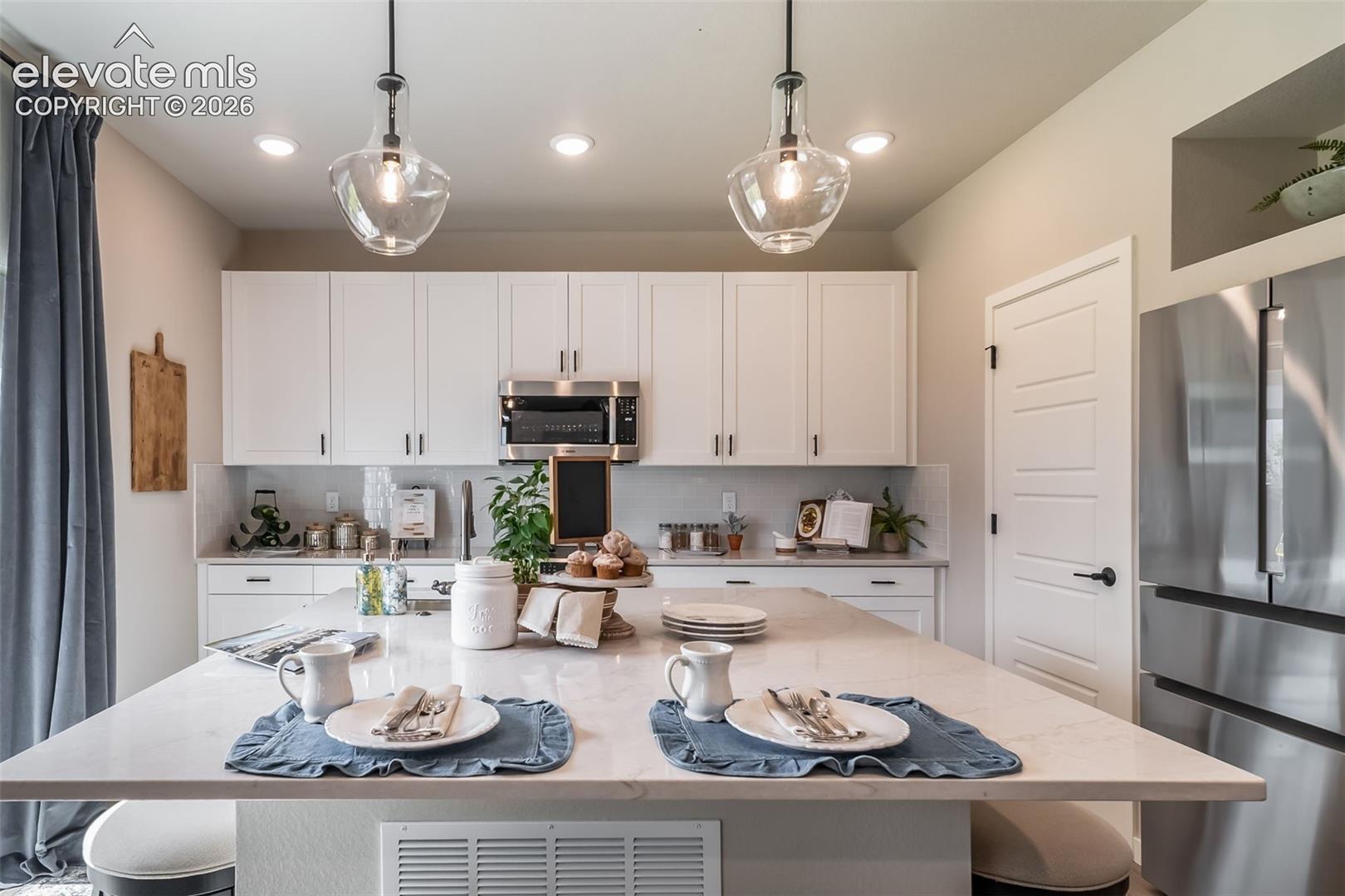 Kitchen featuring a large central island with a light-colored countertop
*Photos of a model home*