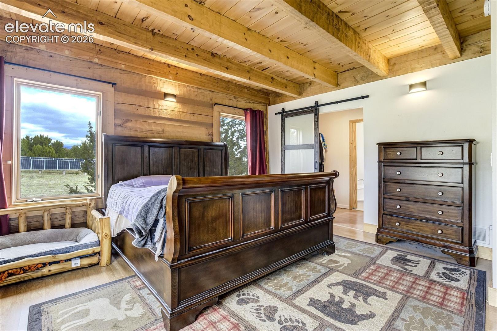 Exposed timber beam ceiling over wood-finish flooring