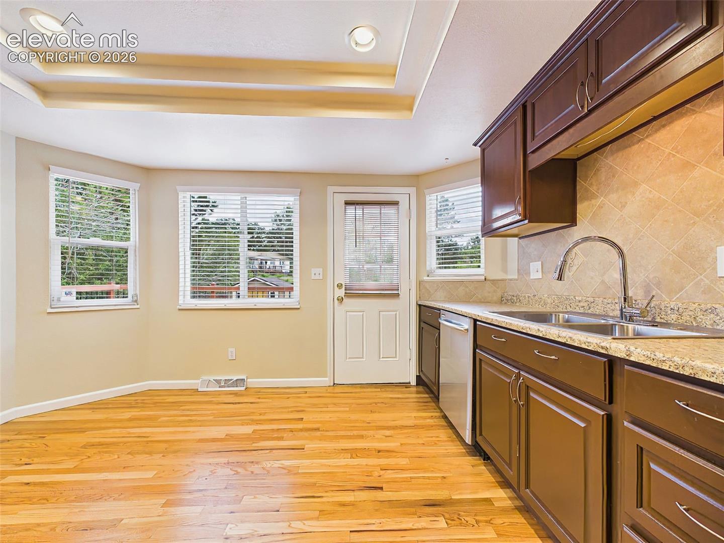 Another view of the spacious eat-in kitchen showcasing ample cabinet storage, laminate countertops, recessed lighting, and generous space for casual dining.