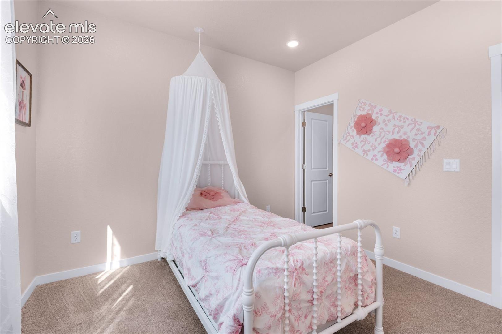 Recessed ceiling lighting, textured wall finish, and carpeted flooring