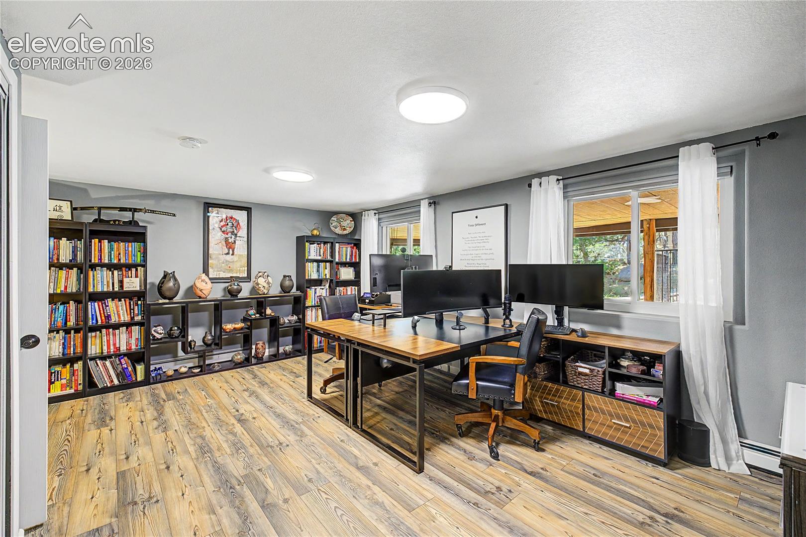 A dedicated home office on the lower level offers space for an additional bedroom featuring large windows, ideal for remote work or a quiet retreat.