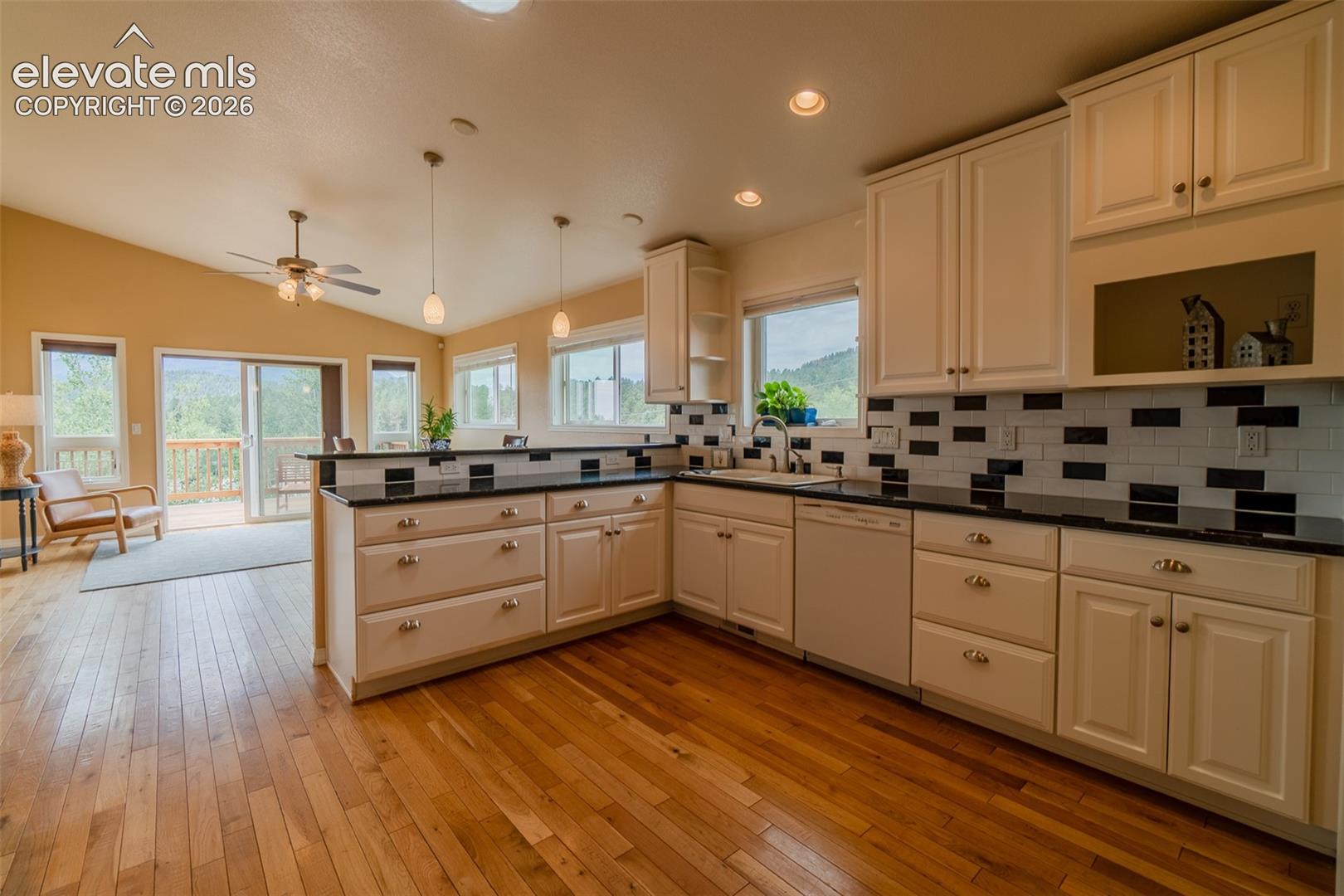Thoughtfully designed kitchen featuring abundant cabinetry, generous counter space, and a spacious breakfast bar that opens to the dining and living areas.