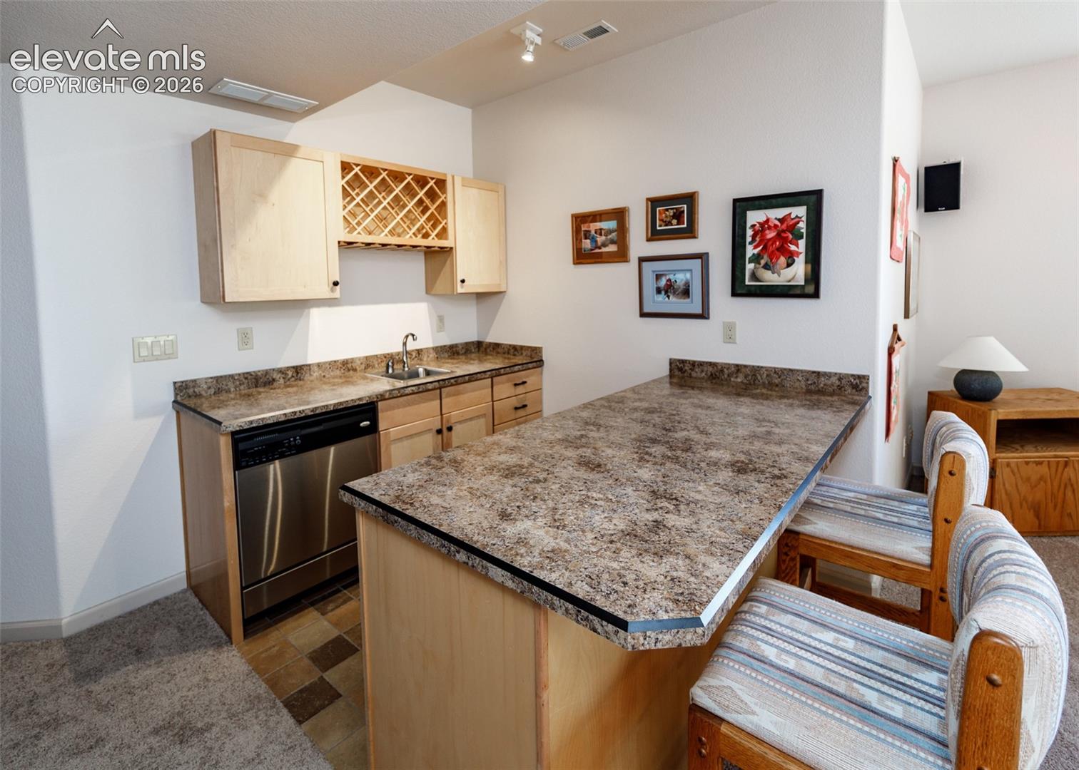 Built-in wet bar also features a stainless steel dishwasher, plenty of storage, wine rack, and ample countertop space