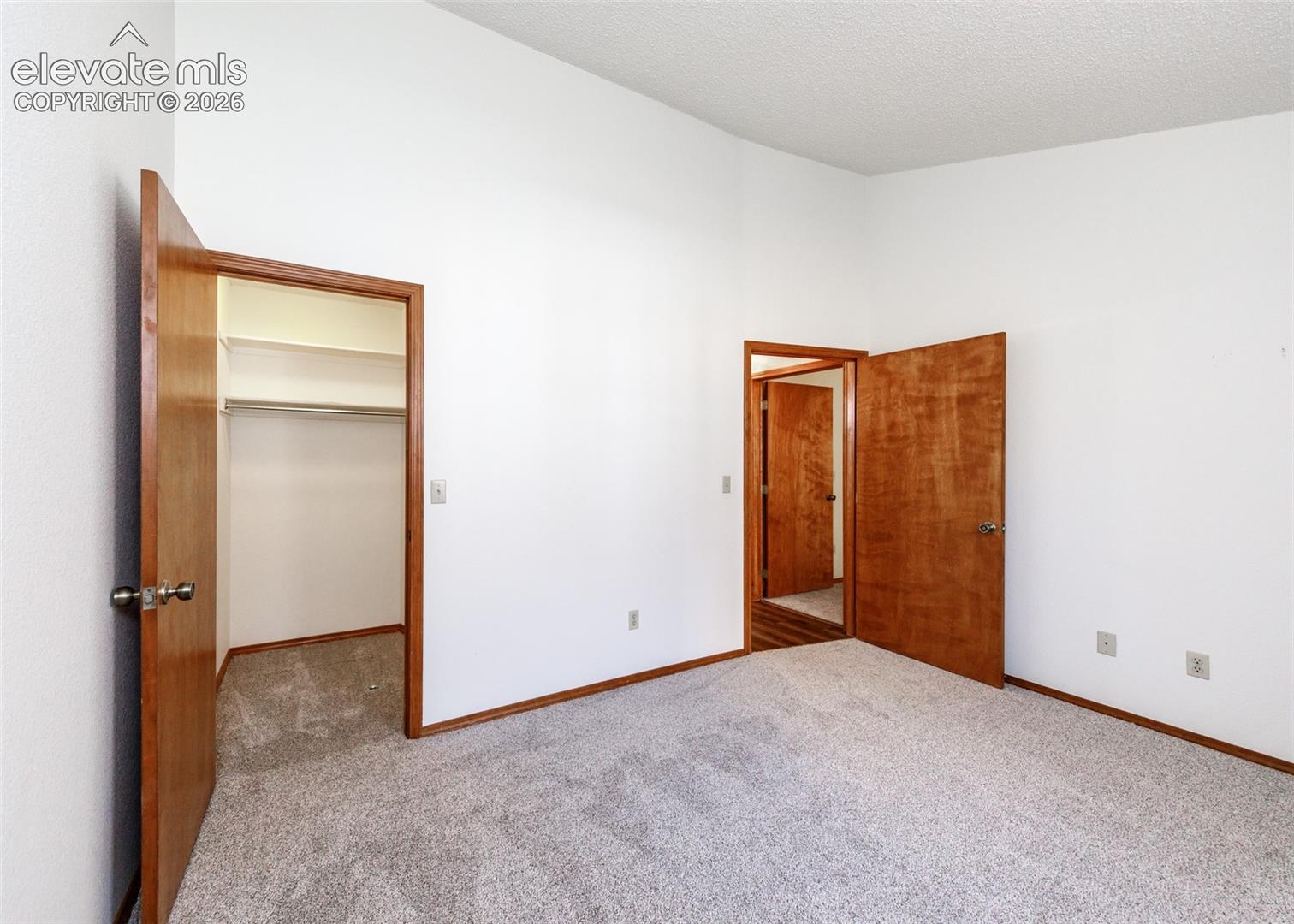 Wall-to-wall carpeting, wood-finish doors, and white walls