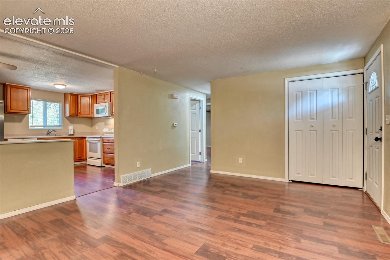 Open concept living area featuring wood-finish flooring