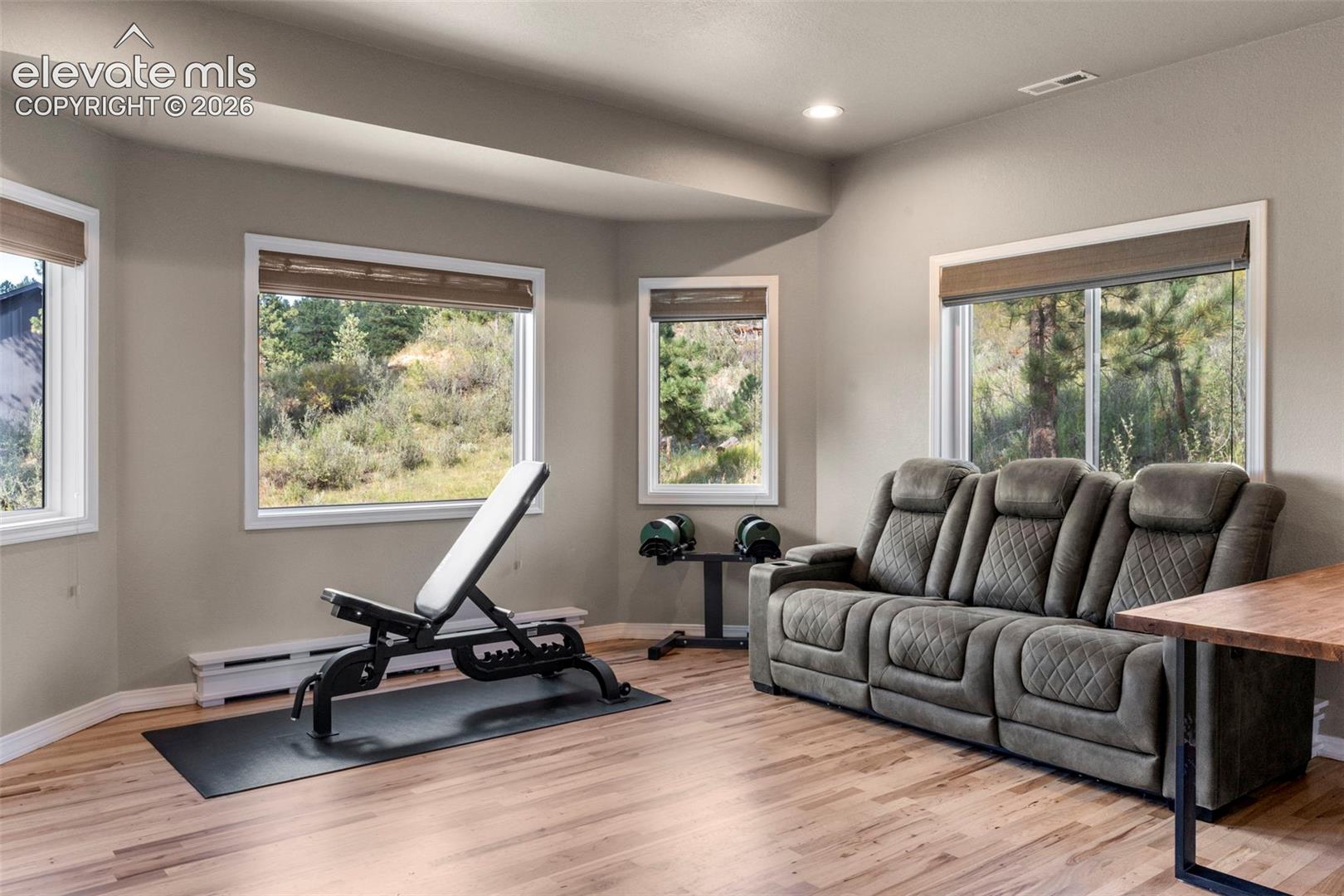 Workout room featuring light wood-type flooring, recessed lighting, and baseboard heating